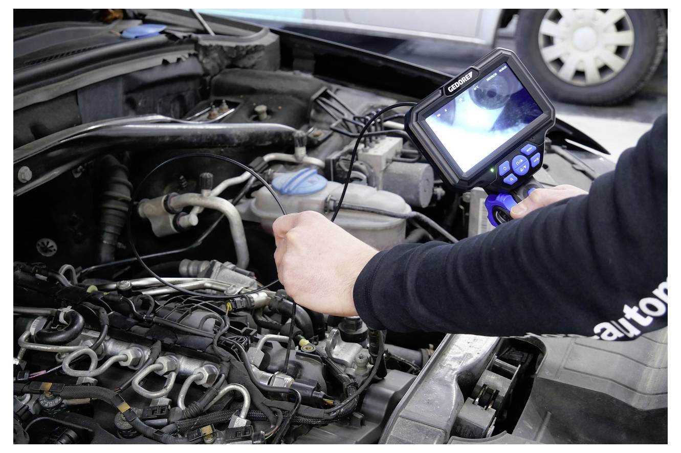 Eine Person verwendet einen Schraubendreher, um einen Autotürverriegelungsmechanismus neben dem Scharnier einer offenen weißen Autotür zu reparieren. Der Türgriff ist sichtbar.