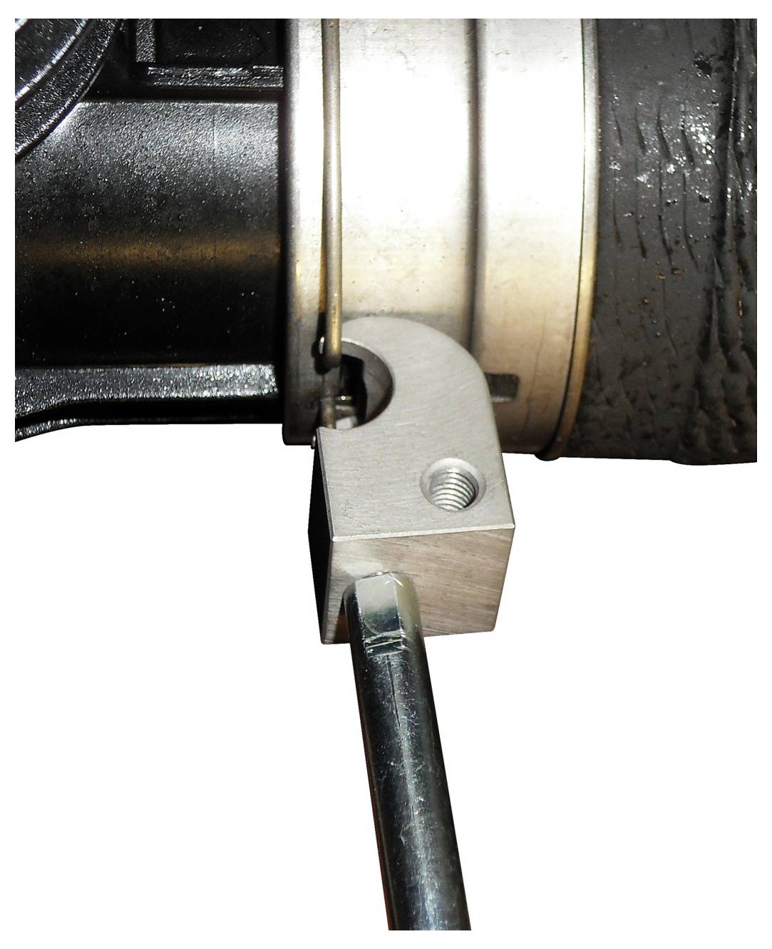 Ein blaues Werkzeug mit der Bezeichnung GEODORE KL-0115-210 entfernt Rost von einer Fahrzeugbremsscheibe mit einem Bohraufsatz. Nahaufnahme.