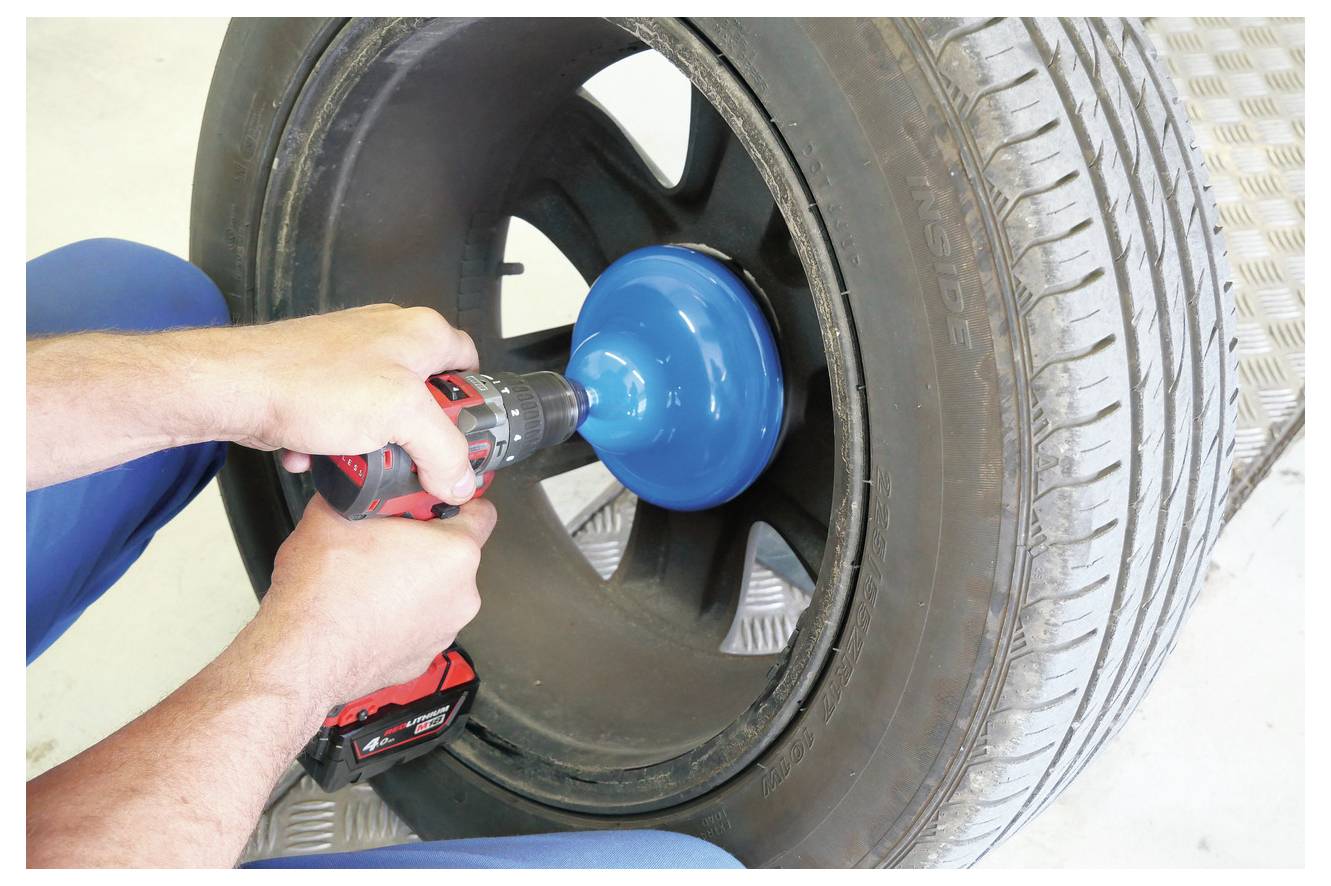 Vier blau-silberne Werkzeuge, einschließlich Zange, Schraubendreher, Steckschlüssel und Ratsche, sind magnetisch an einem Autoseitenpaneel befestigt.