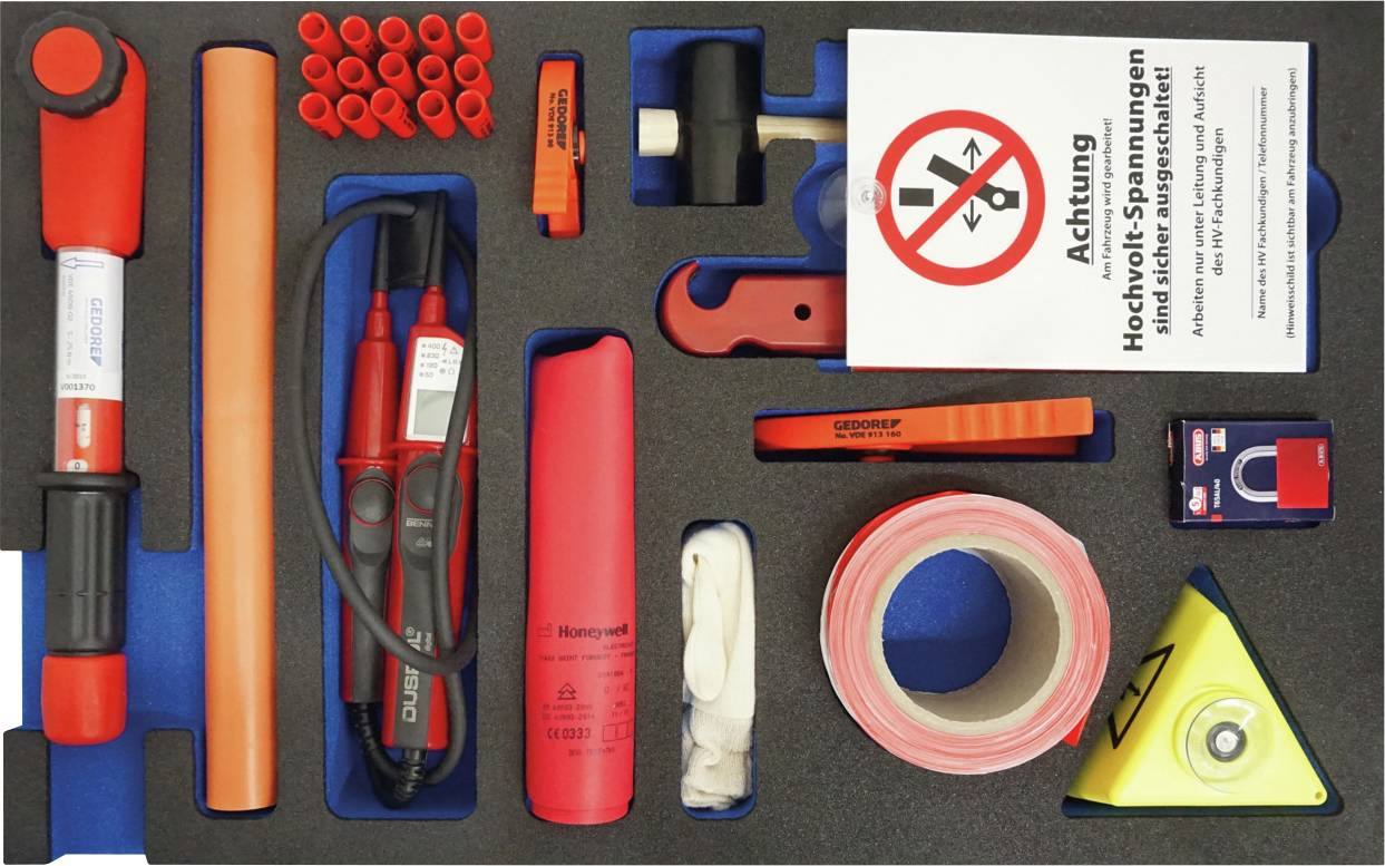 Elektrosicherheitsset mit Werkzeugen und Schutzausrüstung, einschließlich isolierter Handschuhe und Spannungsprüfer, ordentlich in einem Schaum-Organizer angeordnet.