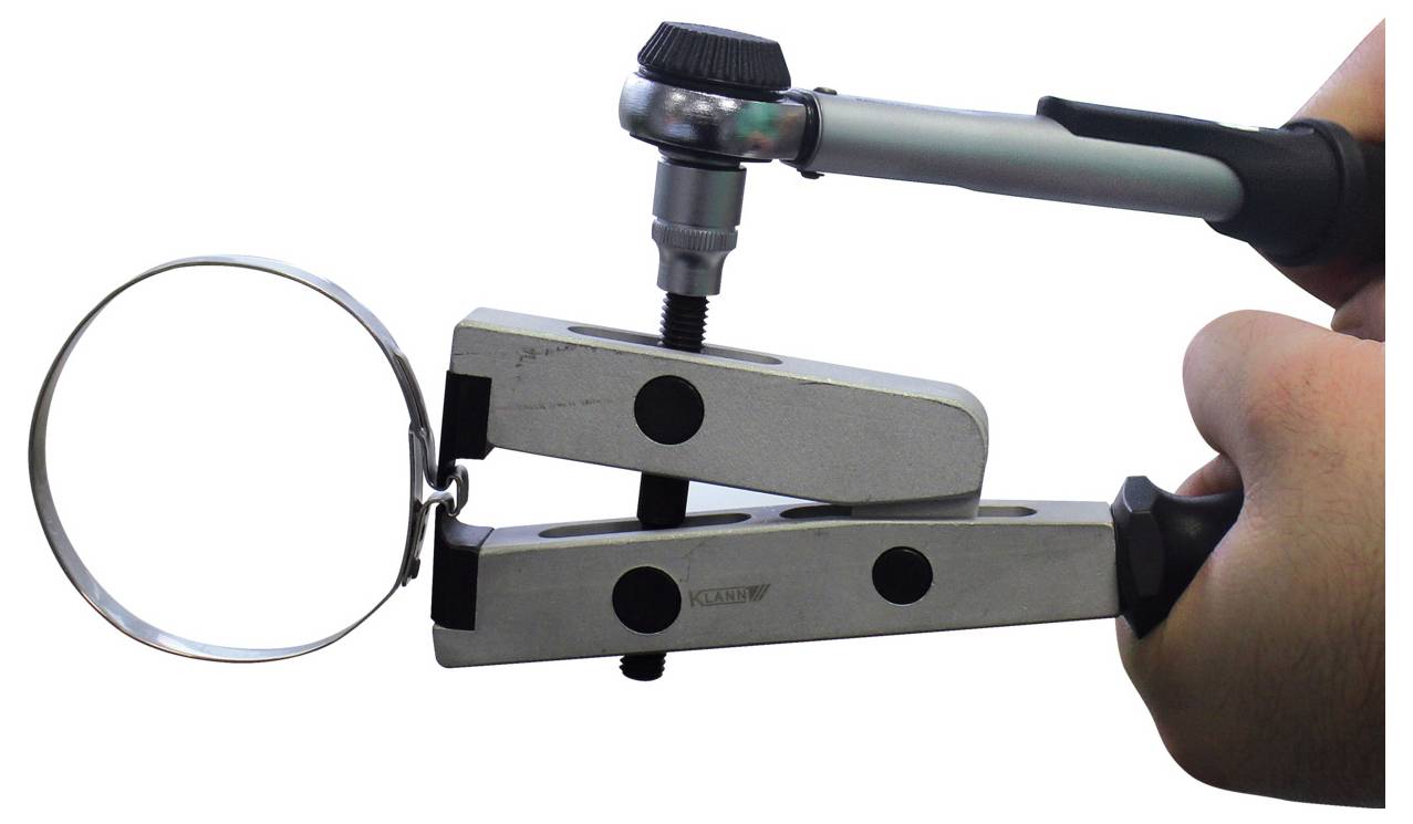 Eine Hand hält einen Drehmomentschlüssel, der eine Klemme mit einem Bolzen anzieht. Die Klemme hat einen Metallring, was darauf hindeutet, dass sie zum Sichern von zylindrischen Objekten verwendet wird.