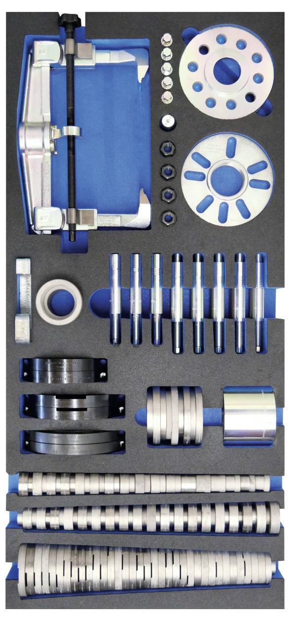 Ein ordentlich organisierter Satz von Präzisions-Metallteilen und Werkzeugen, die in einem schaumstoffgefütterten Koffer angeordnet sind, einschließlich Scheiben, Stangen und kreisförmiger Komponenten.