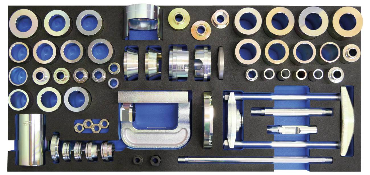 Automatik-Werkzeugsatz auf blauem Hintergrund mit verschiedenen Steckdosen, Ringen und einer C-Klemme, angeordnet in einer Schaumstoff-Ausschnitt für einfachen Zugriff.