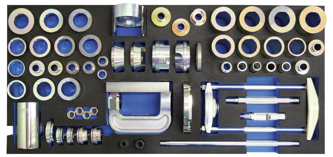 Ein Werkzeugsatz mit verschiedenen Metall- und Kunststoffringen, Klemmen und zylindrischen Teilen, die ordnungsgemäß in einem Schaumstoffkoffer angeordnet sind, verwendet für die Automobilreparatur.