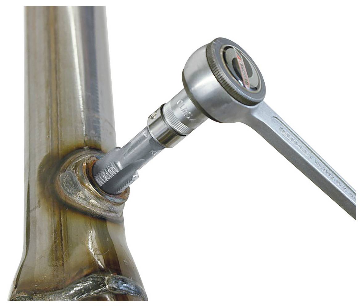 Ein Drehmomentschlüssel zieht eine Mutter auf ein Metallrohr fest und zeigt präzise mechanische Arbeit oder Montage an.