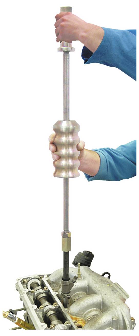 Eine Person verwendet ein Abzieher-Werkzeug, um ein Bauteil aus einem Motorblock zu extrahieren und demonstriert damit einen mechanischen Reparaturprozess.