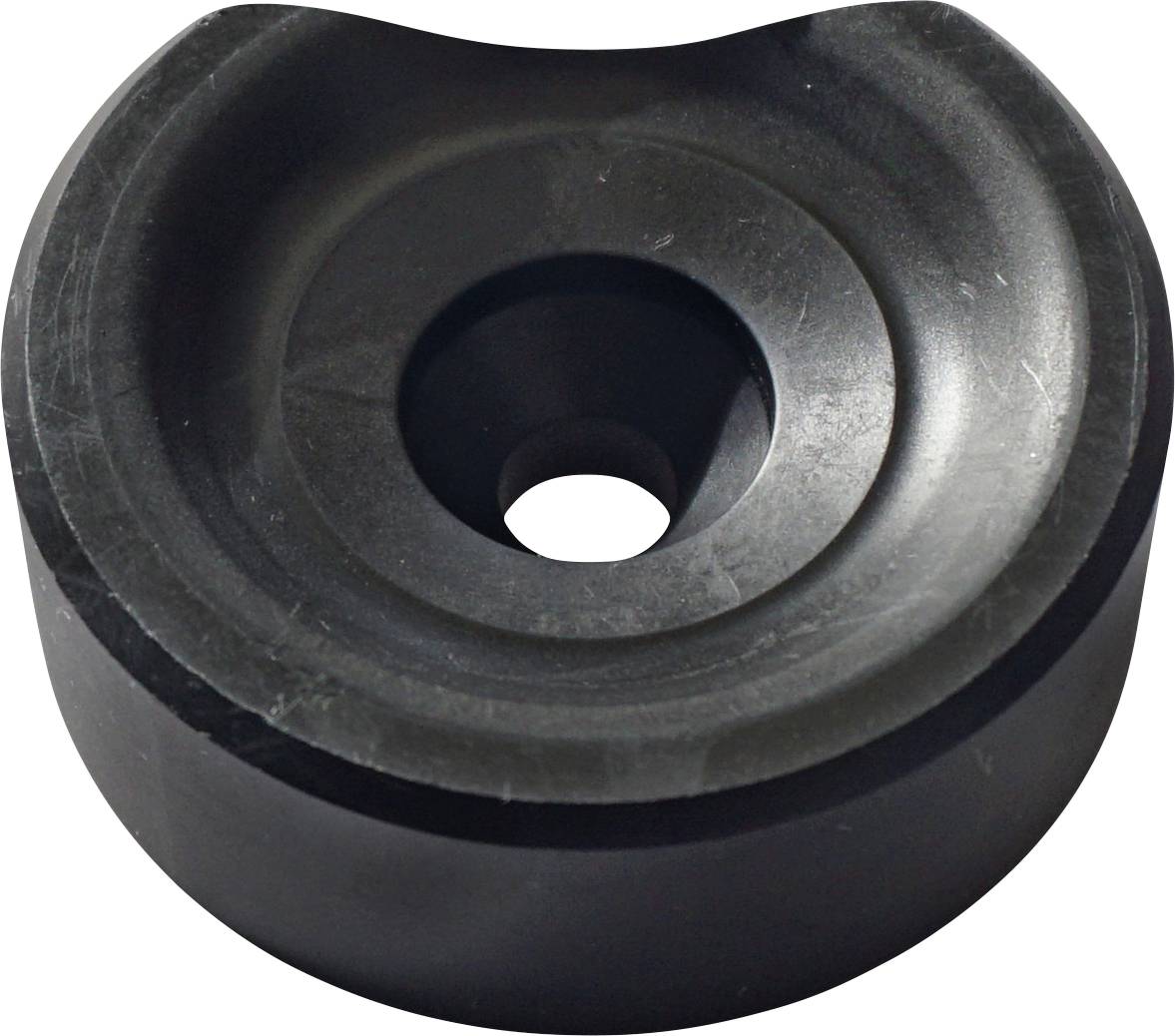Ein rundes, schwarzes Gummiobjekt mit einem zentralen Loch, das einem Ösen- oder Stöpsel ähnelt und möglicherweise zum Dämmen oder Abdichten verwendet wird.