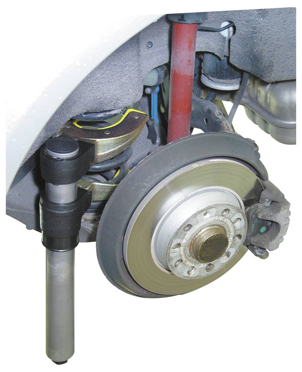 Ein Aufhängungssystem eines Autos mit sichtbarer Bremsscheibe, Stoßdämpfer und Schraubenfeder, das mechanische Komponenten und Struktur zeigt.