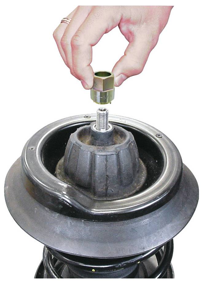 Eine Hand hält eine Metallkappe über einen Stoßdämpfer einer Autofederung und zeigt, wie man sie auf das Gewinde am Ende der Stoßdämpfereinheit aufbringt.