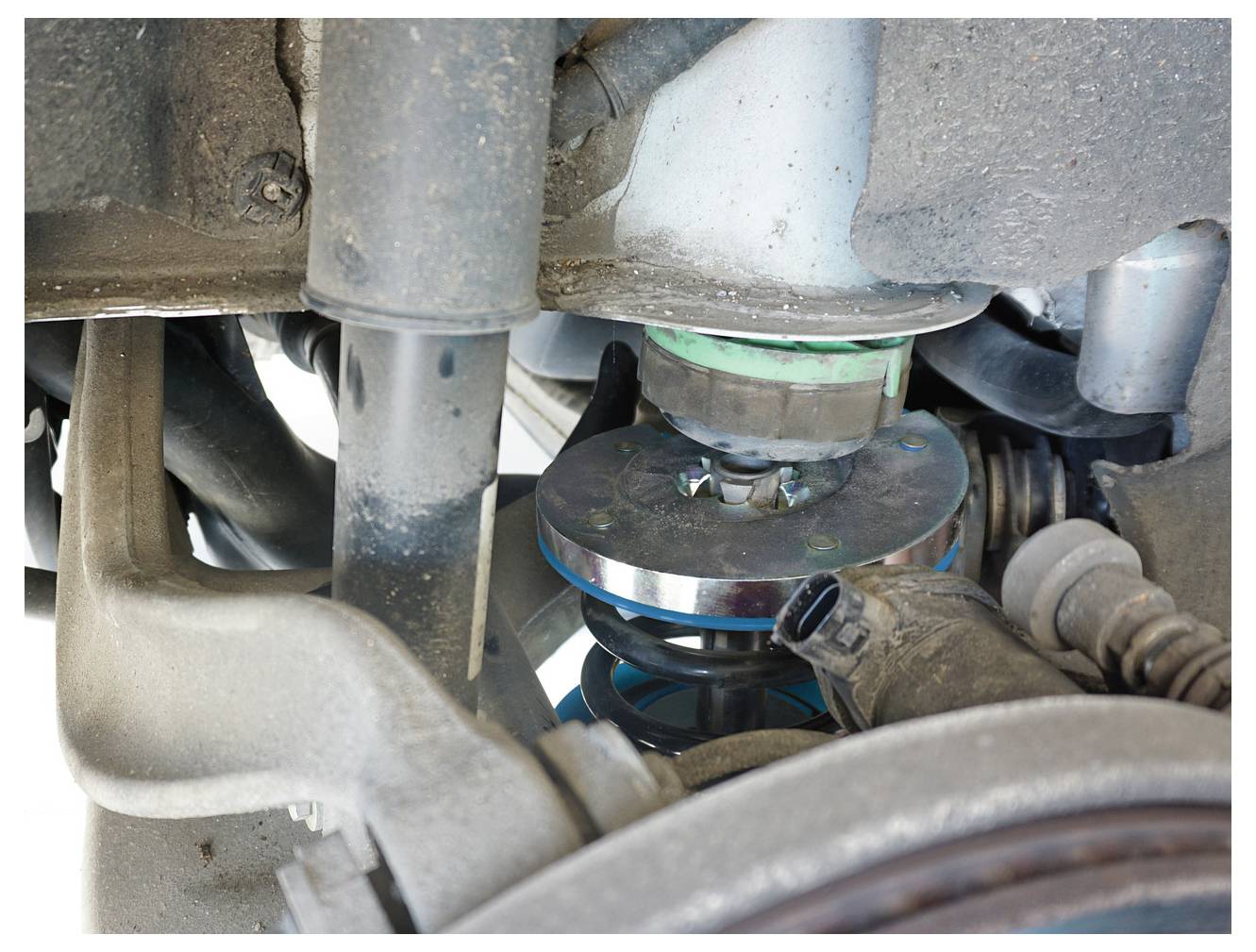 Nahaufnahme des Aufhängungssystems eines Autos, das verschiedene Komponenten wie Federn und Stoßdämpfer zeigt, wobei mechanische Details hervorgehoben werden.