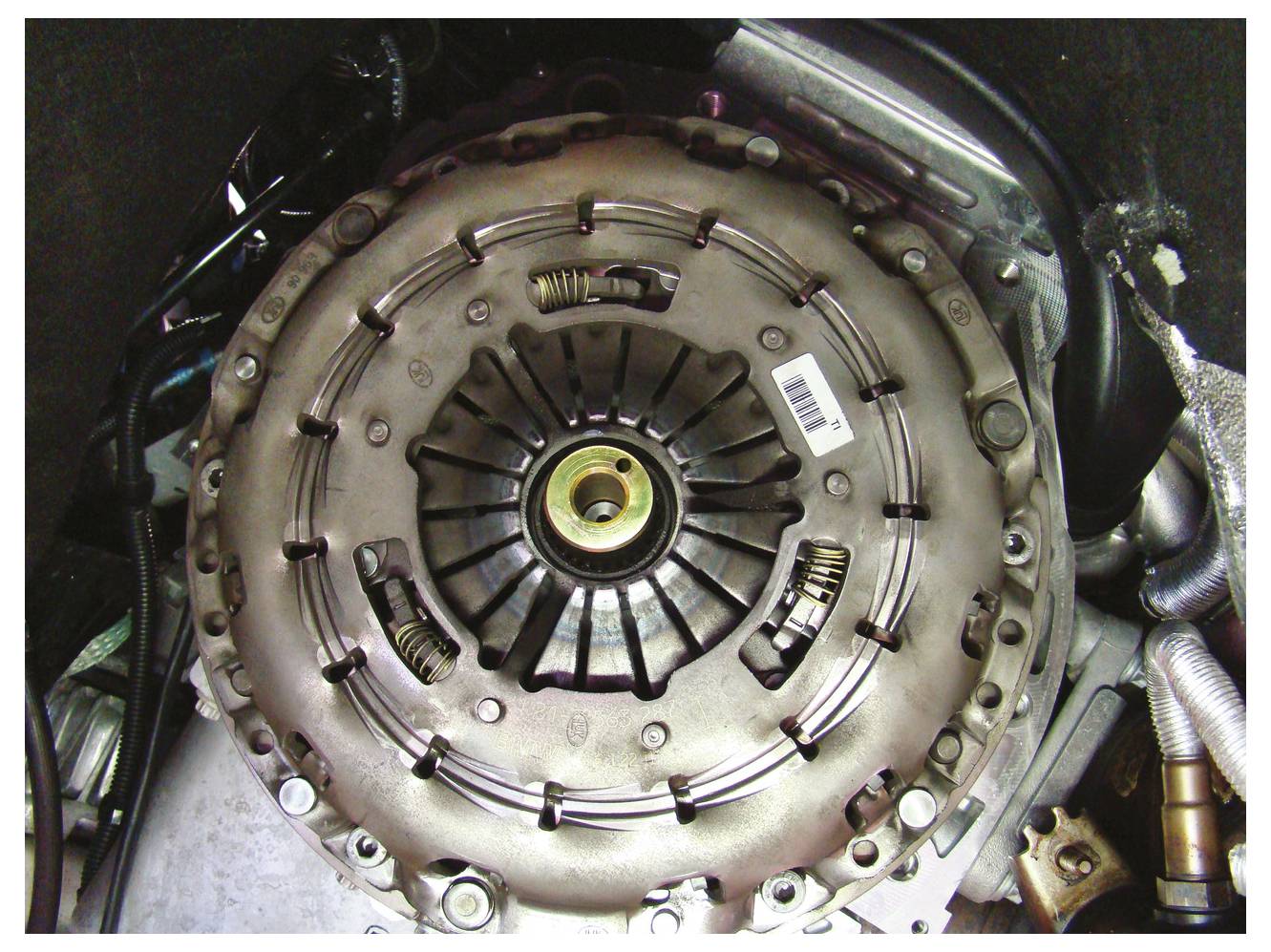 Nahaufnahme einer an einem Motor angebrachten Kupplungseinheit, die die Druckplatte und Kupplungsscheiben-Komponenten im Detail zeigt.