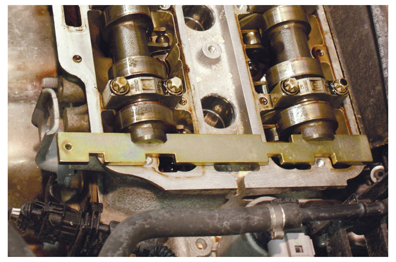 Nockenwellenbaugruppe mit zwei Nockenwellen, Zahnrädern und einer Metallhalterung, zeigt mechanische Komponenten und technische Details.