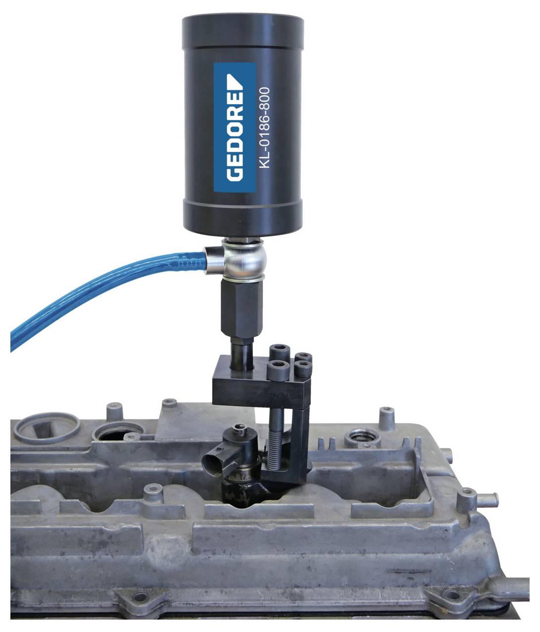 Ein mit 'GEDORE' gekennzeichnetes Werkzeug mit einem blauen Kabel liegt auf einer Metall-Motorkomponente, möglicherweise zu Montage- oder Testzwecken.