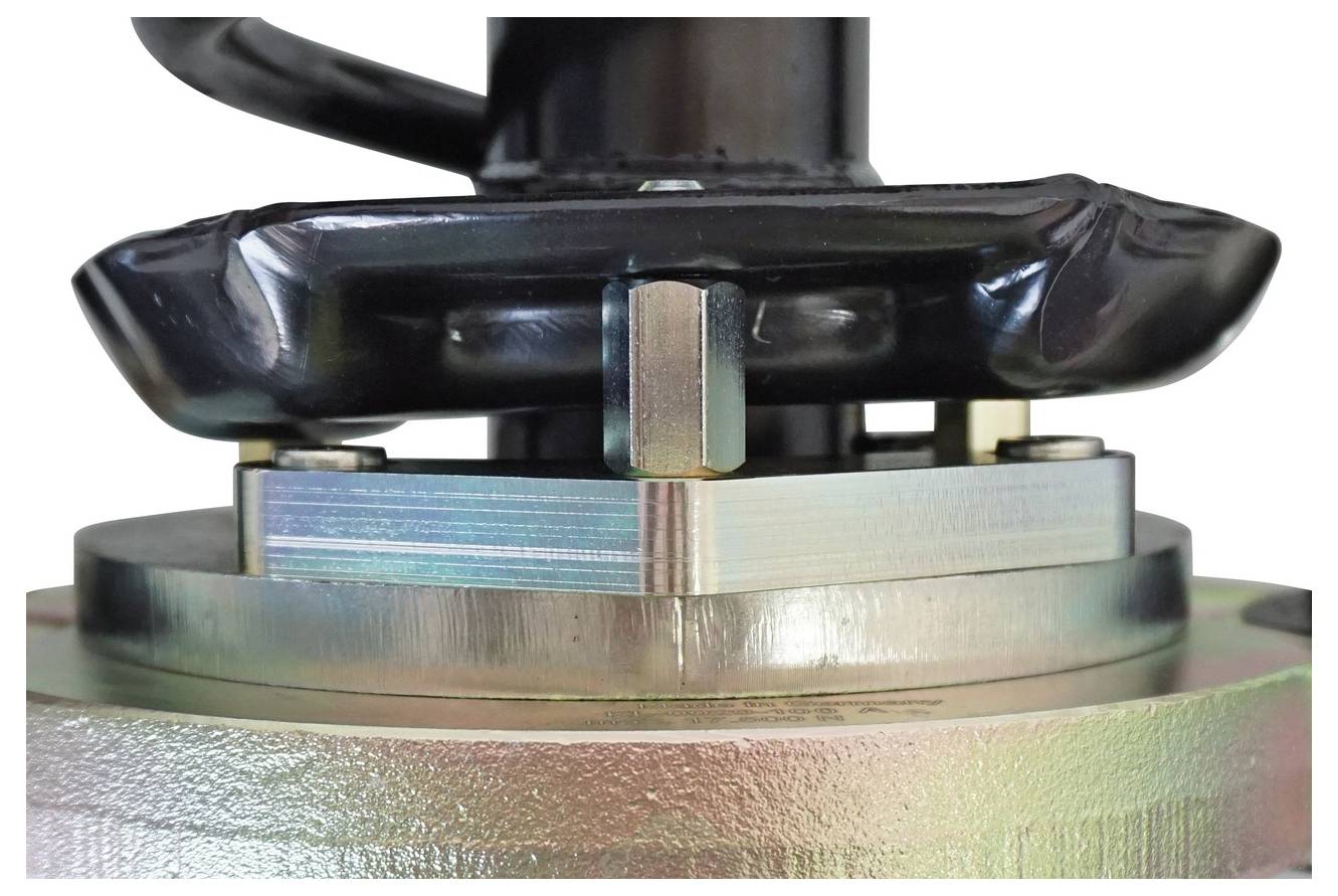 Nahaufnahme von mechanischer Ausrüstung mit einer Metallkomponente, die durch Bolzen gesichert ist. Der Fokus liegt auf der detaillierten Textur und Montage.