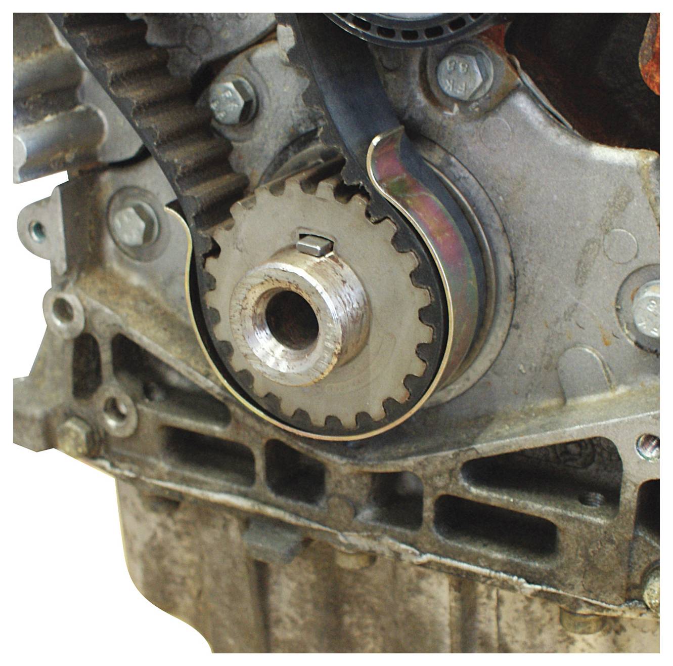 Eine Nahaufnahme einer Motorkomponente mit einem Zahn- und Riemensystem, wobei mechanische Teile und Verbindungen hervorgehoben werden.