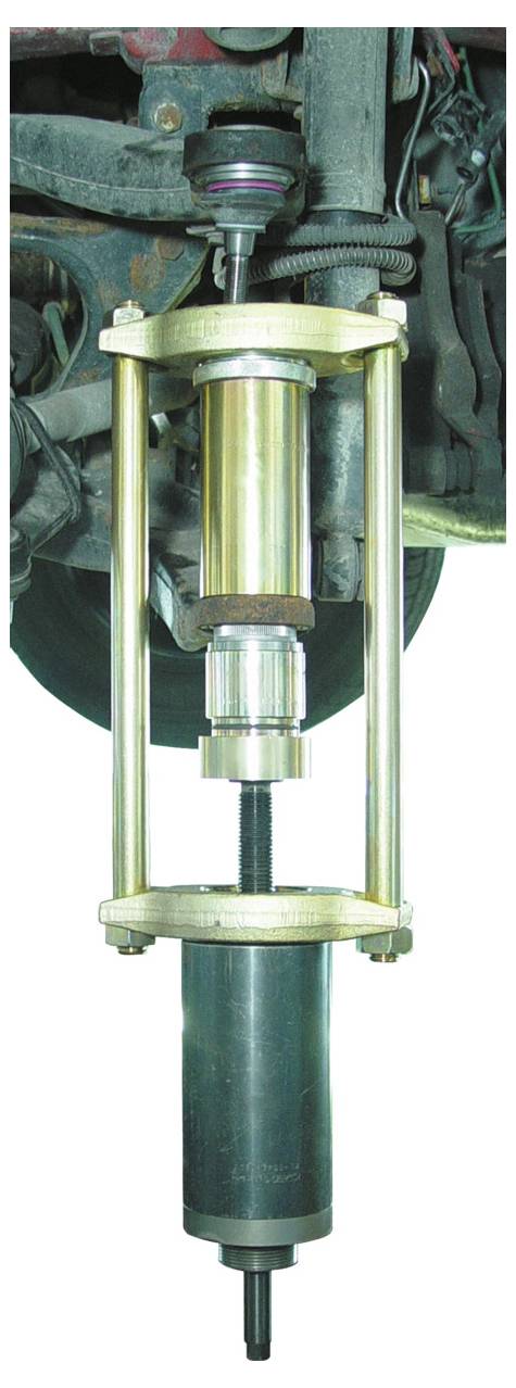 Ein Foto einer metallischen mechanischen Komponente mit zylindrischen und gewindeten Teilen, möglicherweise ein rotierendes oder verbindendes Gerät, vor weißem Hintergrund.