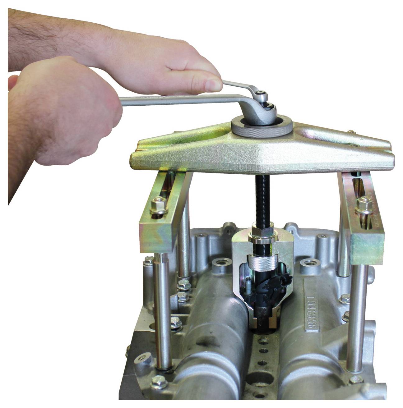 Eine Person verwendet ein mechanisches Werkzeug, um ein mechanisches Bauteil aus einem Motorblock zu ziehen, was einen Schritt beim Auseinandernehmen des Motors darstellt.