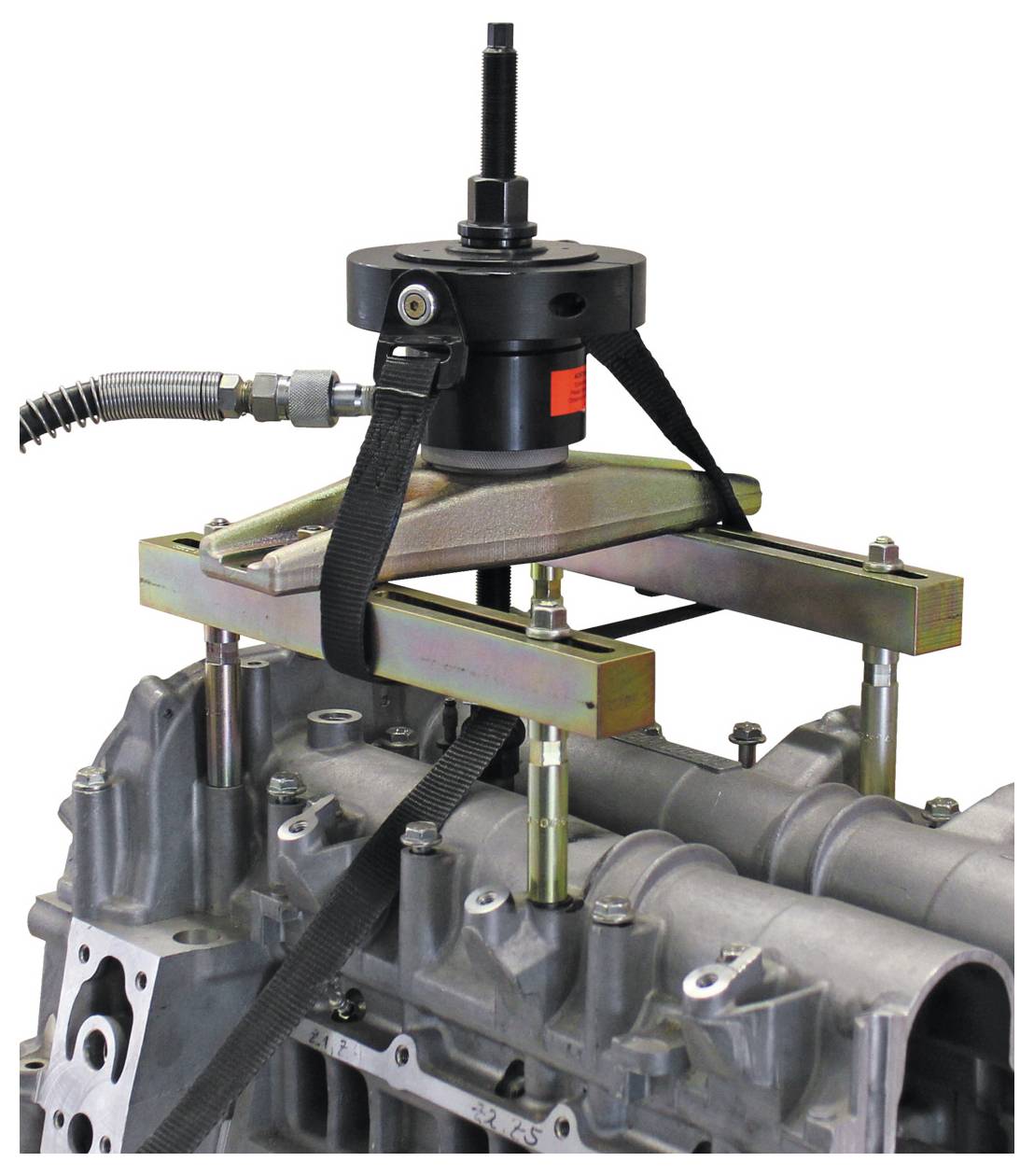 Motorstützbalken mit angebrachtem Hebelwerkzeug an einem Motorblock, das Wartungsausrüstung für Fahrzeuge zeigt.