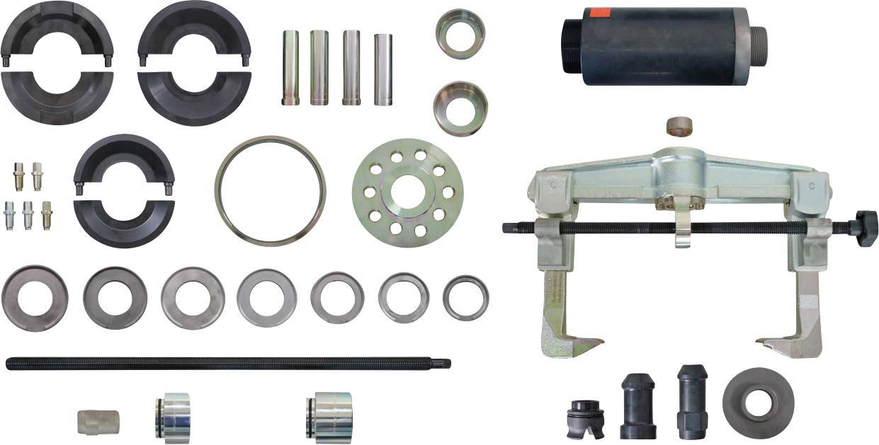 „Verschiedene Autowerkzeuge ausgelegt, darunter Rollen, Stifte, Ringe und ein Abzieher-Werkzeug, verwendet für Fahrzeugwartungs- und Reparaturarbeiten.