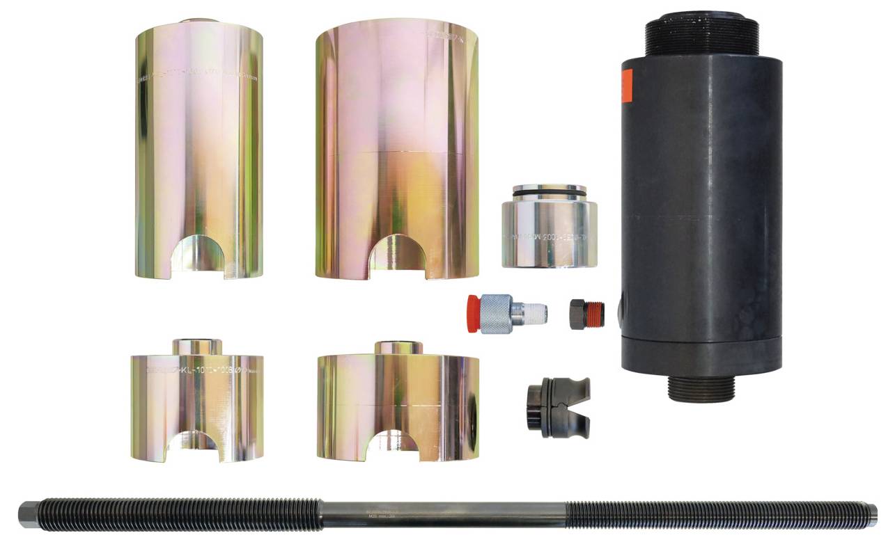 Ein Satz mechanischer Werkzeuge, darunter verschiedene metallische zylindrische Komponenten, ein hydraulischer Wagenheber und eine Gewindestange, auf weißem Hintergrund angeordnet.