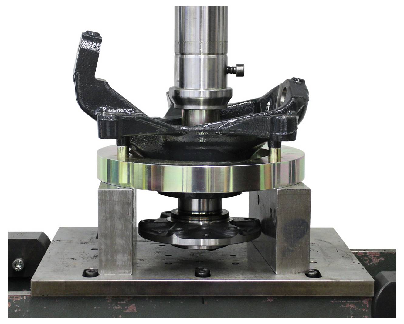 Ein Metall-Objekt, das auf einer Maschine einer Festigkeitsprüfung unterzogen wird, mit Spannvorrichtungen, die zur Stabilität darum herum positioniert sind.