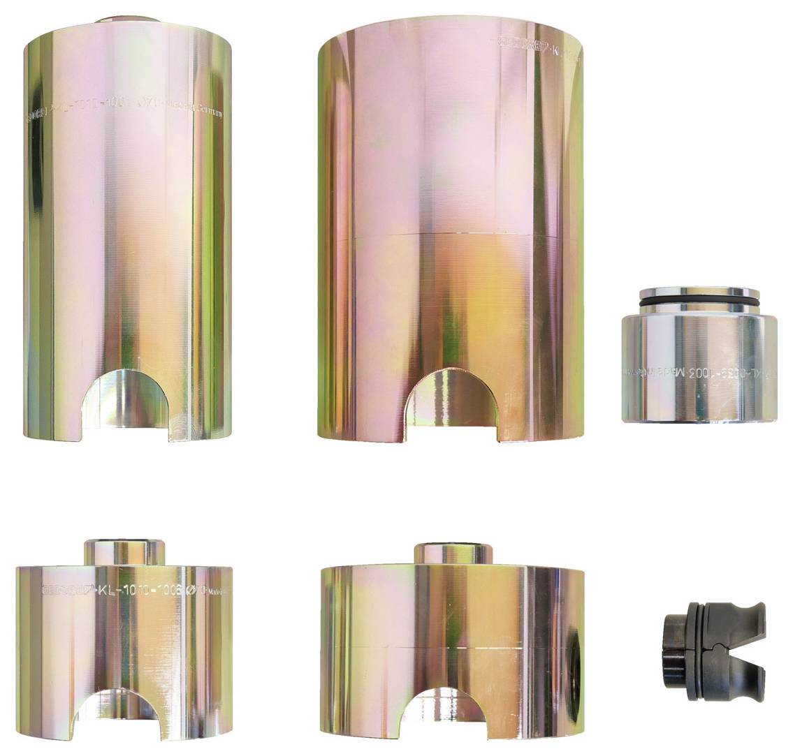 „Satz von sechs metallischen zylindrischen Komponenten mit Rillen, unterschiedlich in Höhe und Durchmesser, vor weißem Hintergrund präsentiert.