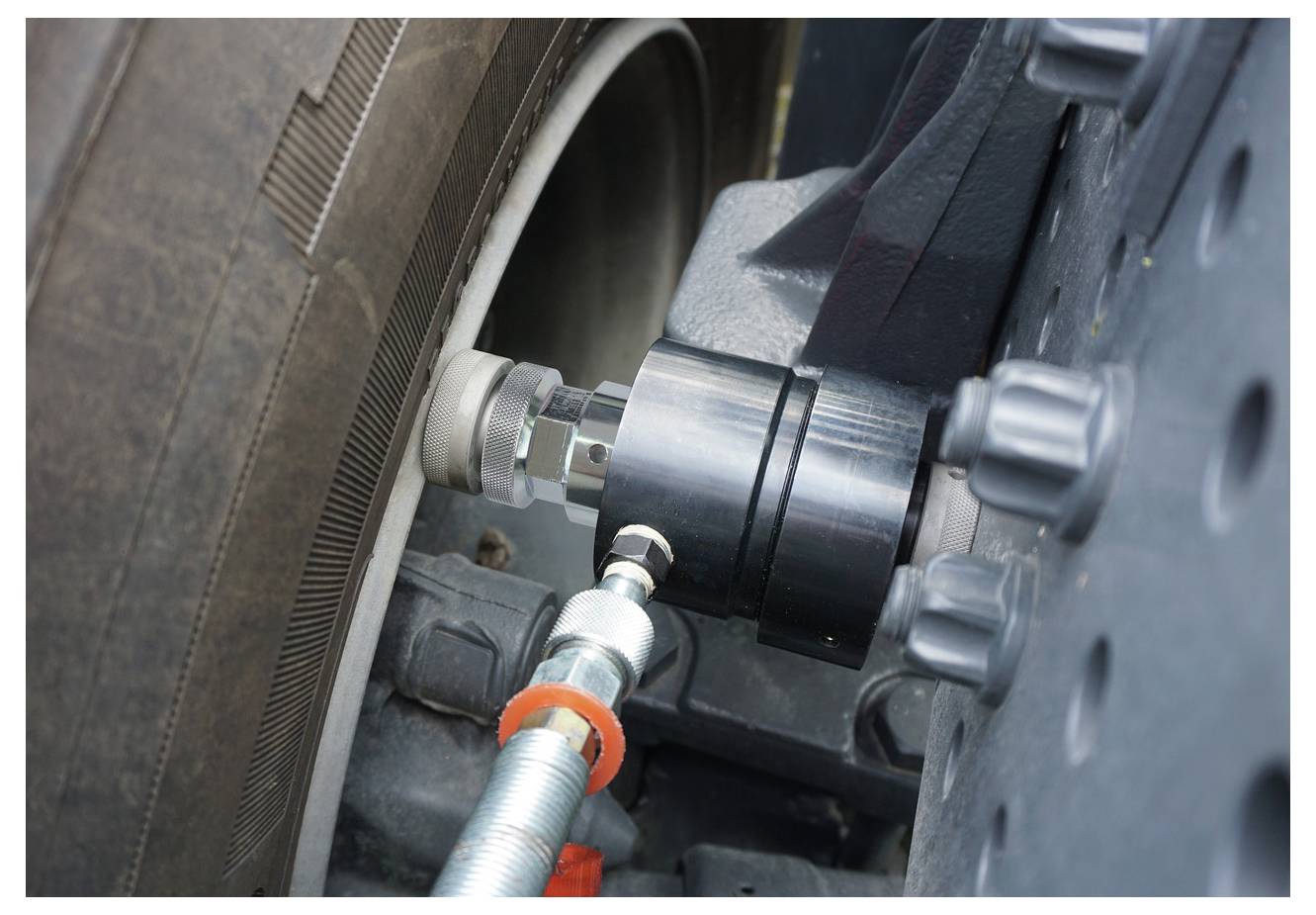 Eine Nahaufnahme einer Bremsen- oder Radkomponente eines Fahrzeugs, die mit einem Messinstrument getestet wird.