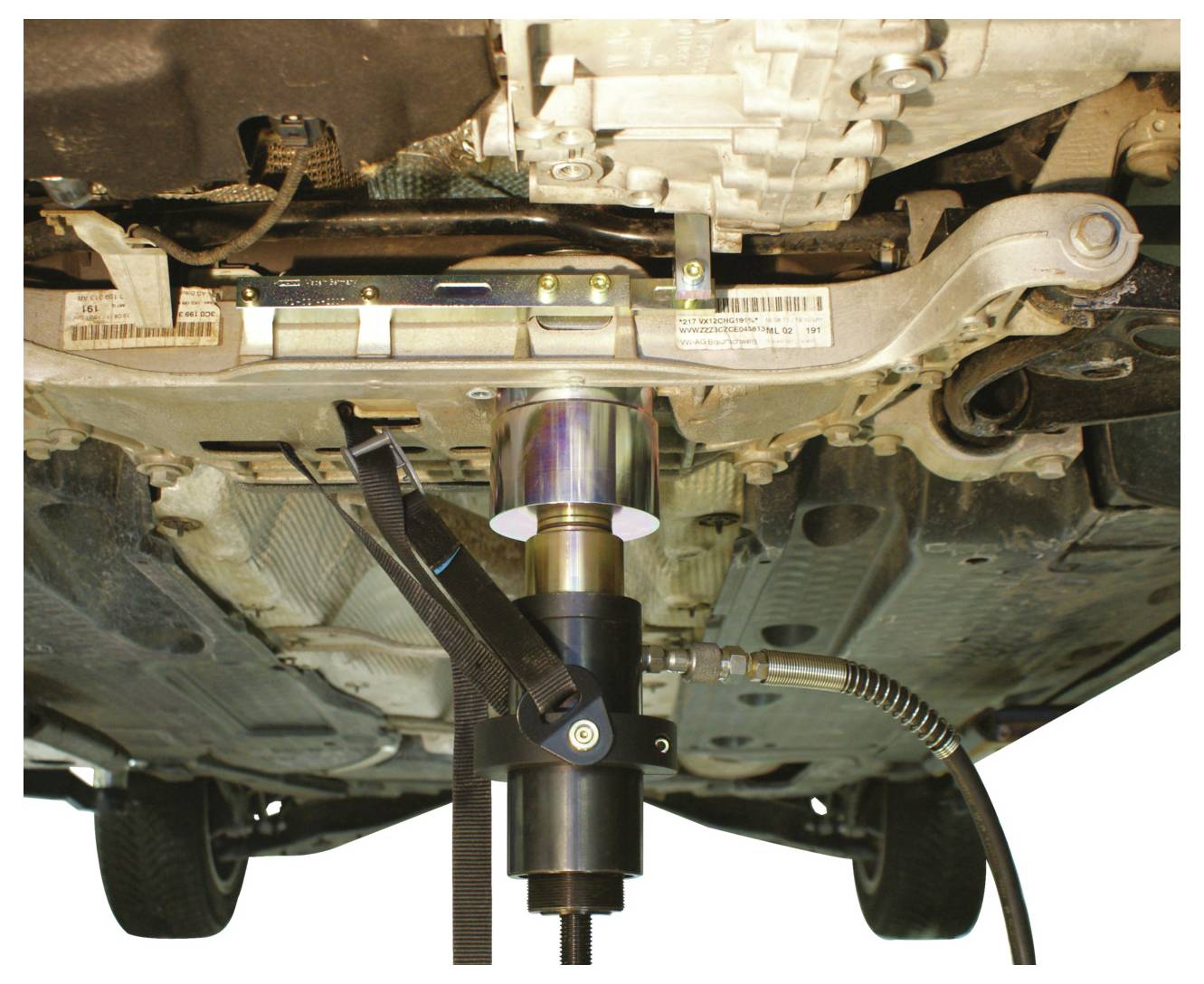 Ein Motorenwerkzeug stützt die Unterseite eines Autos und zeigt einen Getriebeheber, der eine Fahrzeugkomponente zum Reparieren oder Warten hebt.