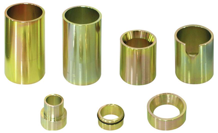 Sieben zylindrische Metallteile in verschiedenen Größen und Oberflächenbearbeitungen sind vor einem weißen Hintergrund angeordnet und präsentieren Industriekomponenten.