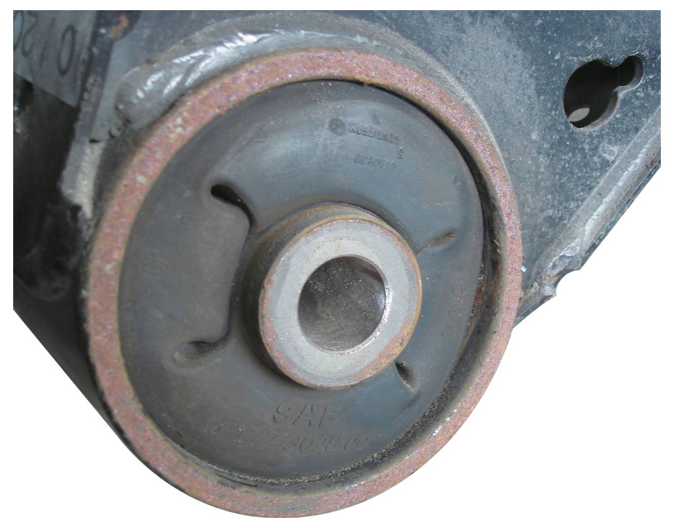 Nahaufnahme eines rostig gewordenen Metallteils, möglicherweise ein Lager oder eine Riemenscheibe, mit einem zentralen Loch und abgenutzten Kanten, das in Maschinen oder Technik verwendet wird.