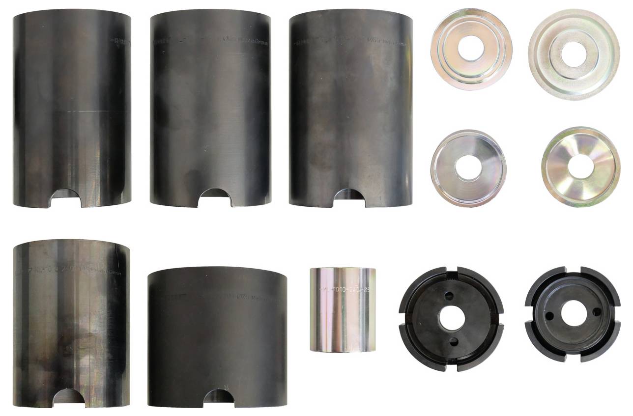 Ein Satz verschieden großer schwarzer Metallhülsen, Ringe und kreisförmiger Teile, die in Reihen angeordnet sind, vermutlich Komponenten für mechanische Montage.