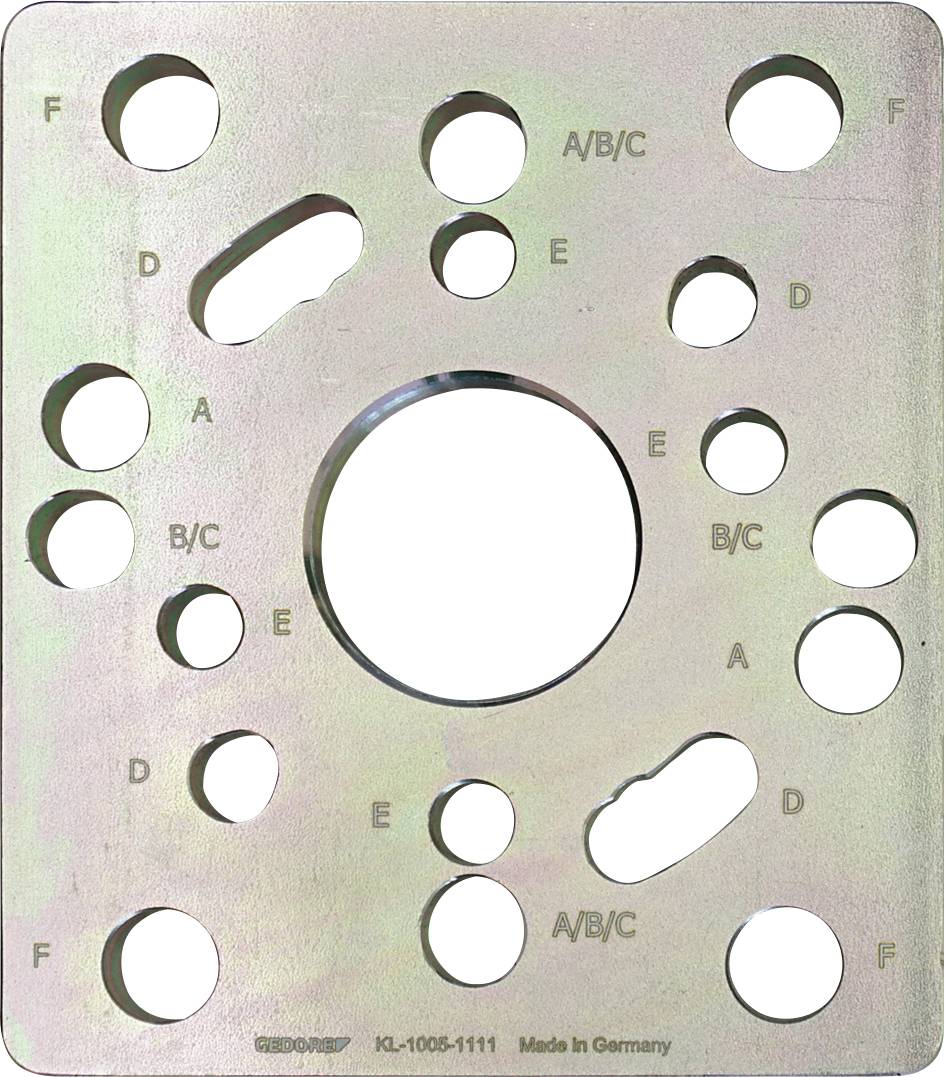 Eine rechteckige metallische Schablone mit verschieden großen Löchern, die mit „A/B/C
