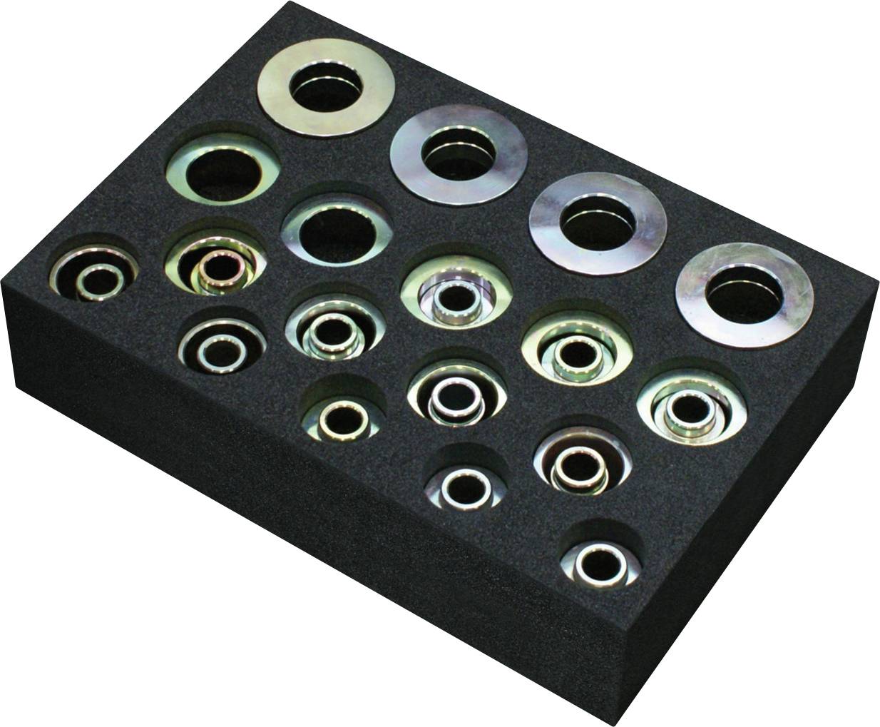 Ein schwarzes Schaumstoffblech mit 18 assortierte flachen Unterlegscheiben, die in drei Reihen angeordnet sind und in Größe und metallischem Farbfinish variieren.