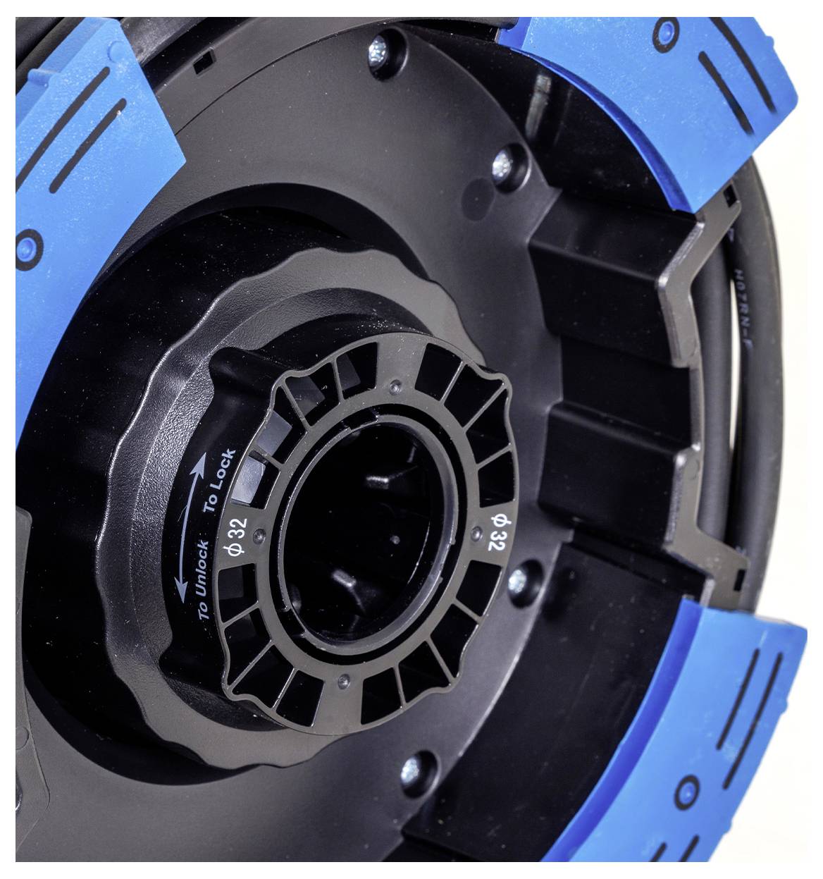 Nahaufnahme einer Spulenbaugruppe mit blauen und schwarzen Segmenten. Die Spule zeigt Beschriftungen zum Sperren und Entsperren sowie Größenmarkierungen 'Ø82' und 'Ø32'.