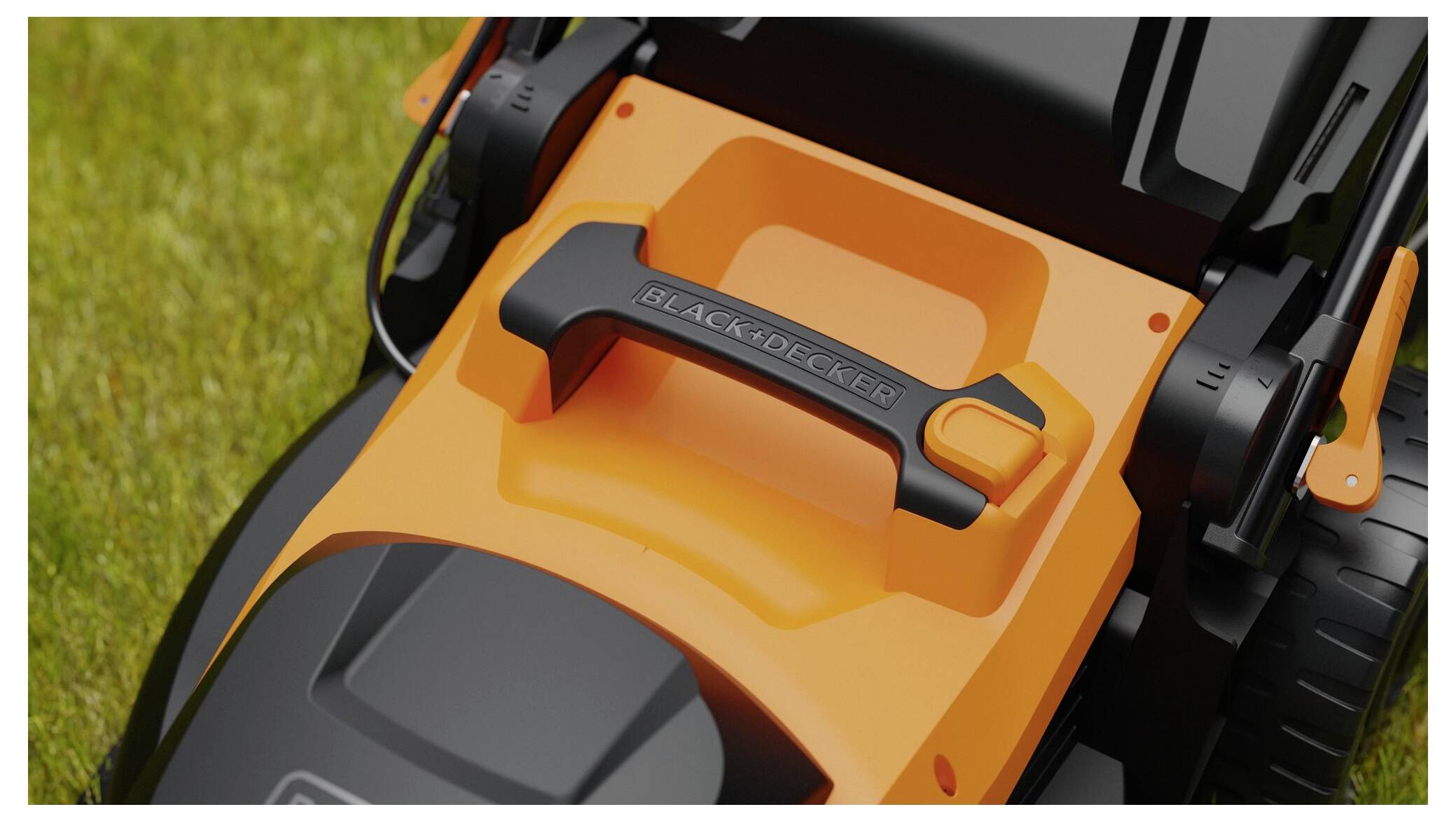 Ein Nahaufnahmen eines schwarz-orangenen Rasenmähers Griff auf Gras, das das Markenlogo auf dem Griff zeigt.