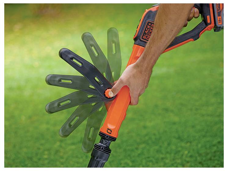 Eine Hand stellt den Winkel eines BLACK+DECKER Rasenwerkzeugs mit orangefarbenem Griff und mehreren Blatt-Positionen auf einem grünen Rasen ein.