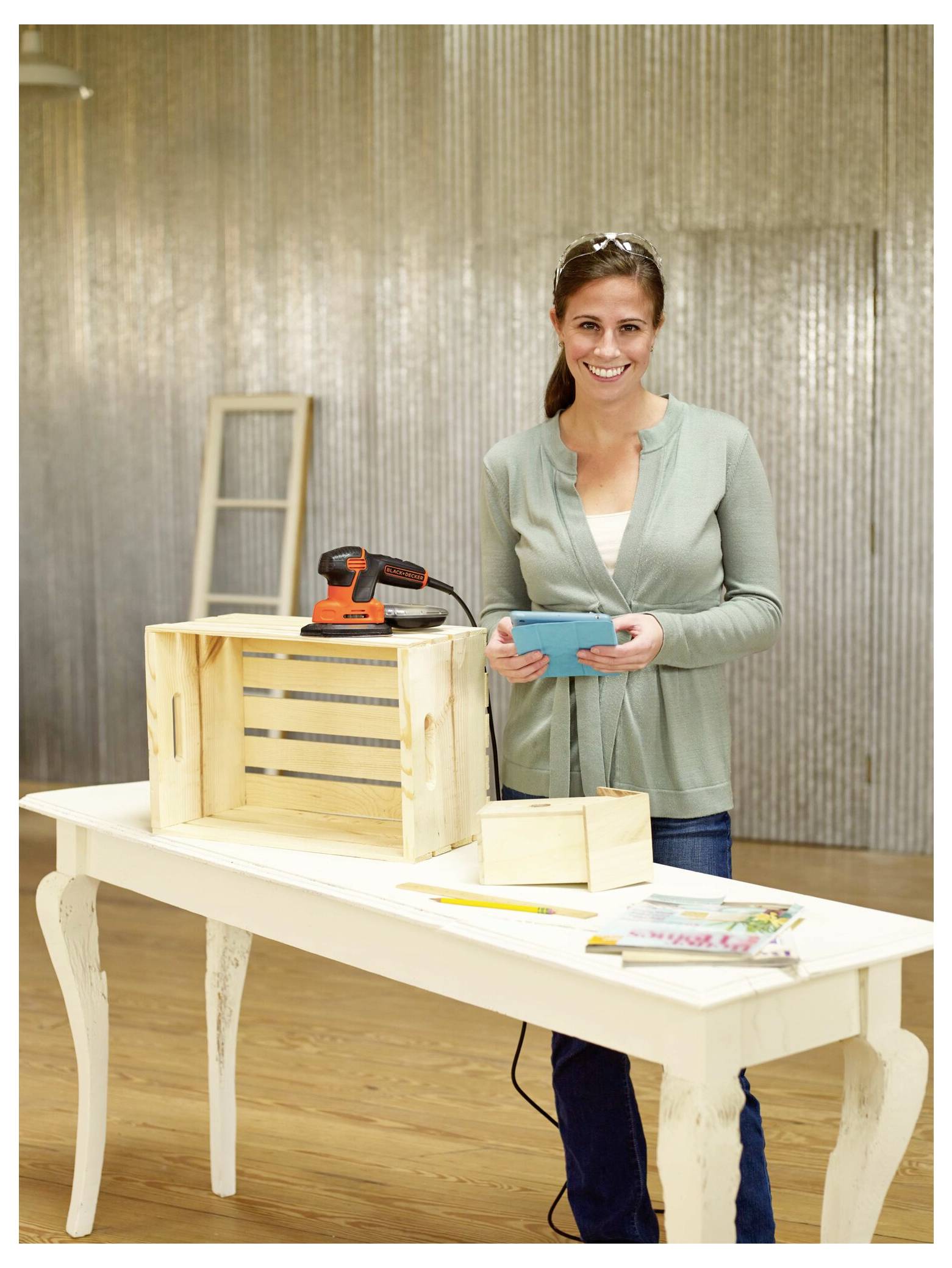 Eine Person stellt die Kappe an einer orangefarbenen Kettensäge ein, die auf einer Holzoberfläche liegt.