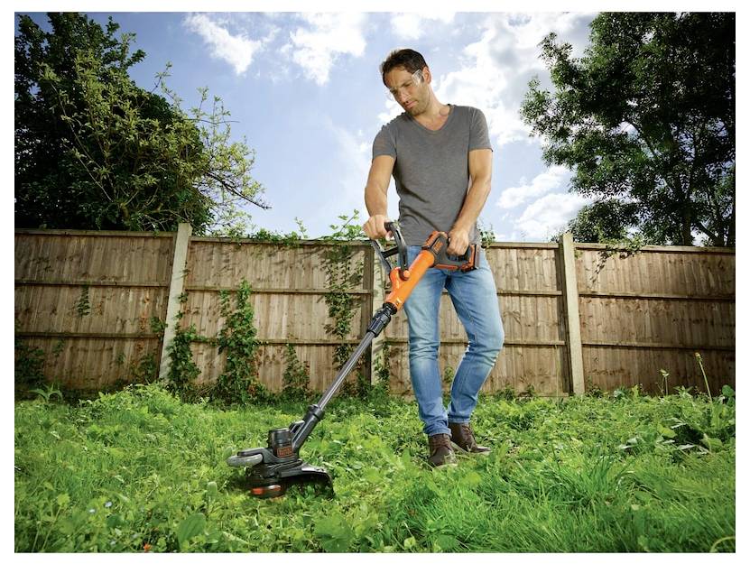 Ein orange-schwarzer kabelloses Heckenschneider mit horizontalem Messer. Der Griff ist ergonomisch, und die Marke „Black+Decker