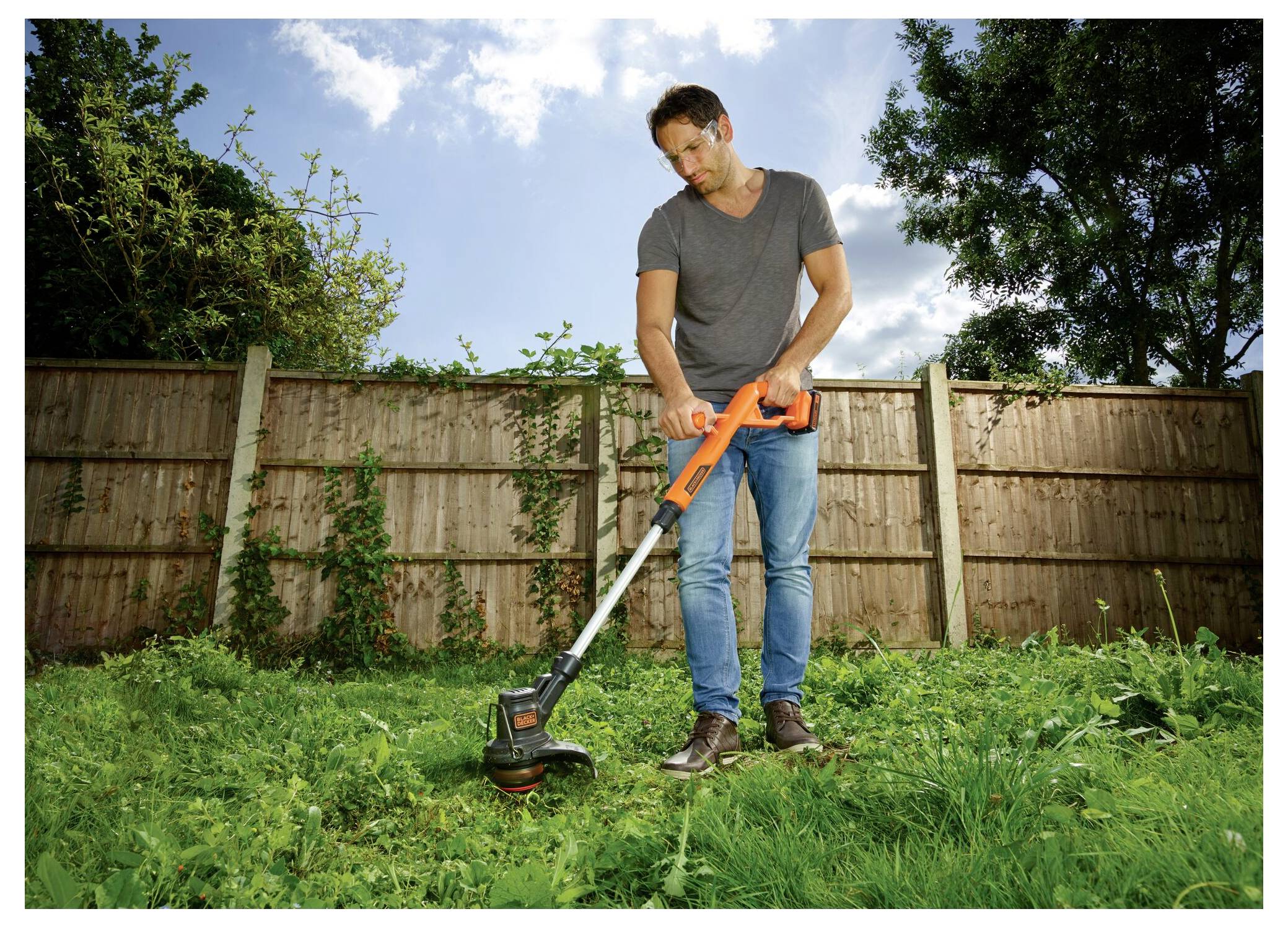 Eine orange-schwarze kabellose Handgeräte-Heckenschere von Black & Decker mit kompaktem Design und scharfen, doppelwirkenden Klingen.