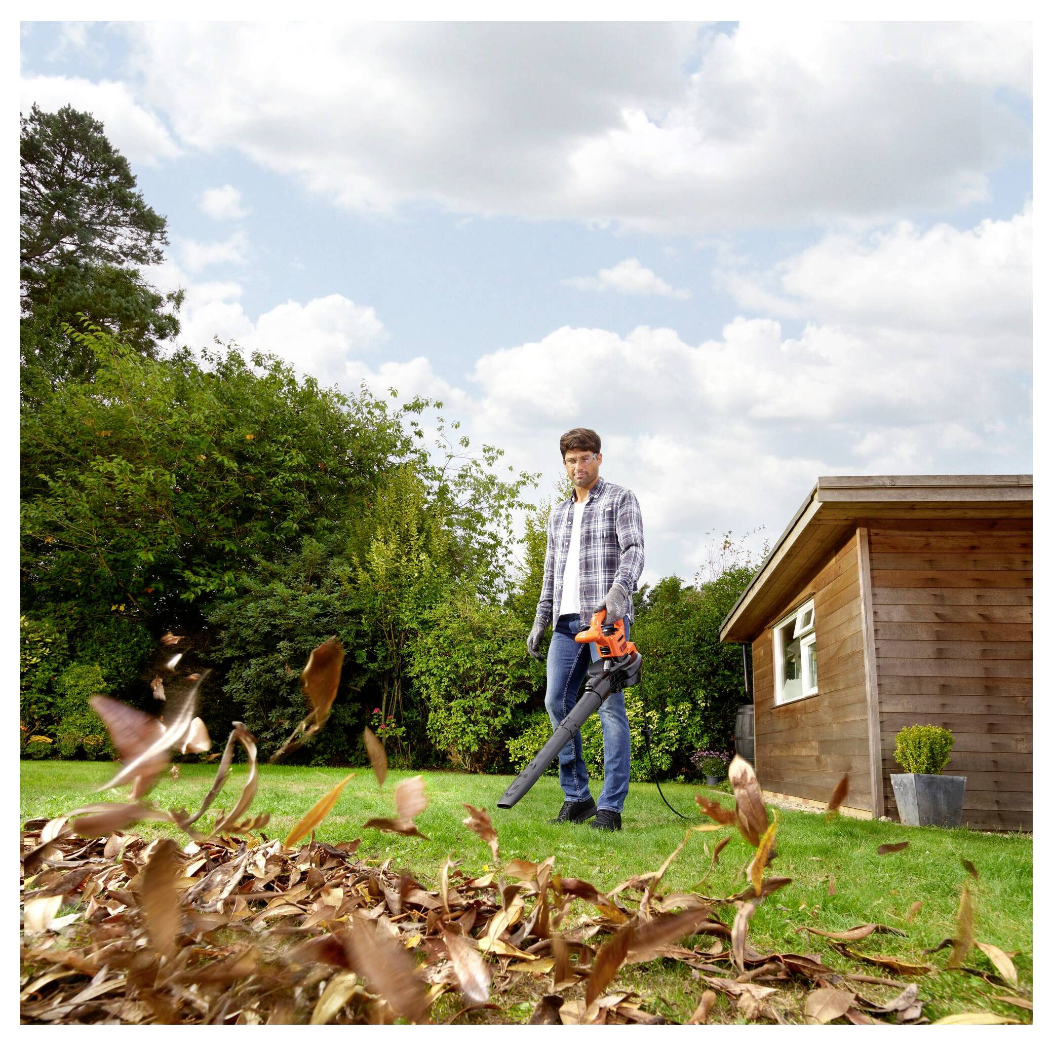 Eine Person verwendet ein Elektrowerkzeug, um Fliesen von einem Boden zu entfernen, was zu zerbrochenen Teilen führt, die überall verstreut sind. Das Werkzeug wird mit Handschuhen gehalten.