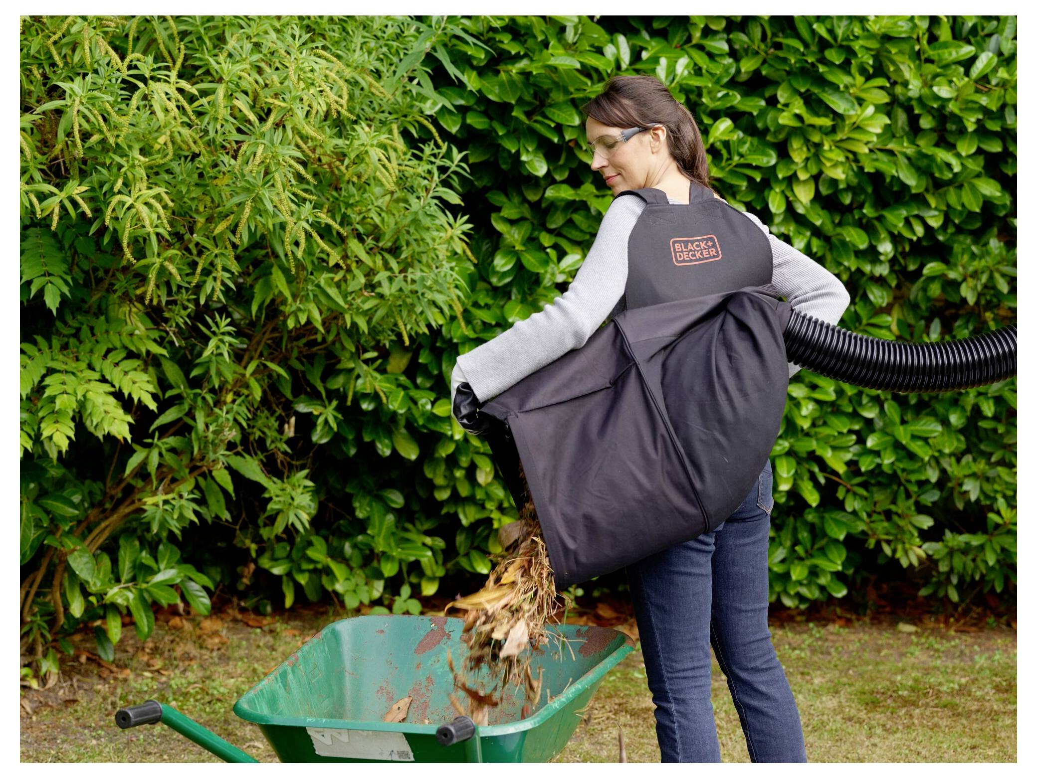 Eine orange elektrische Heckenschere mit langer Klinge und ergonomischem Griff.