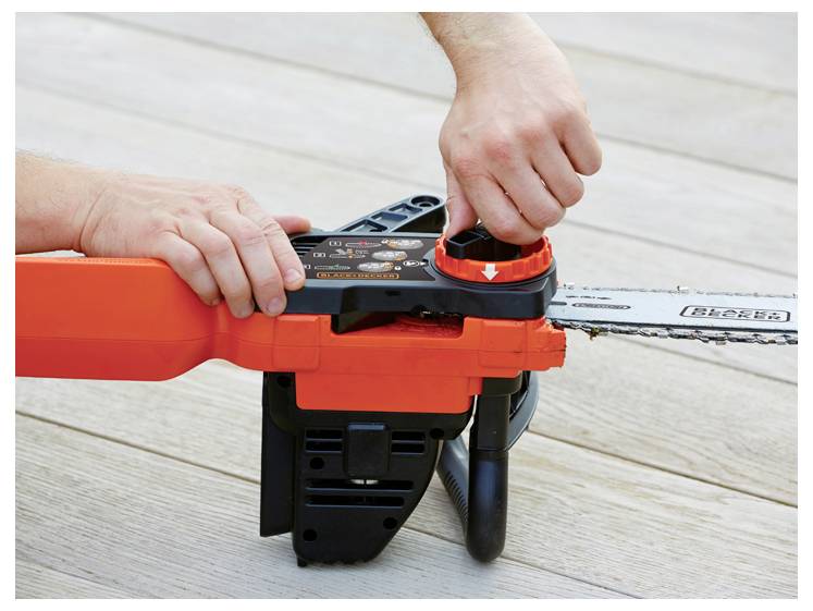 Eine Person in Jeans und rotem Hemd hält eine rot-schwarze Kettensäge im Freien, bereit zum Einsatz in einem Graspflanzgebiet mit Bäumen im Hintergrund.