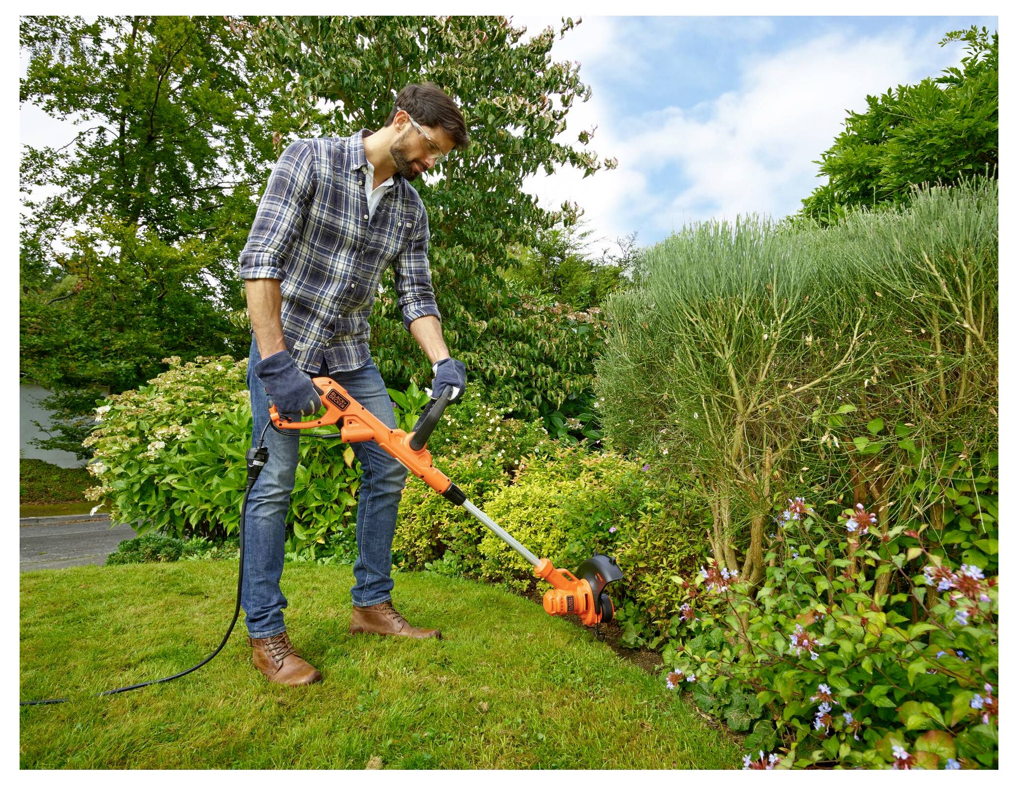 Orange und schwarze kabellose Heckenschere mit langer Klinge, Marke „BLACK+DECKER