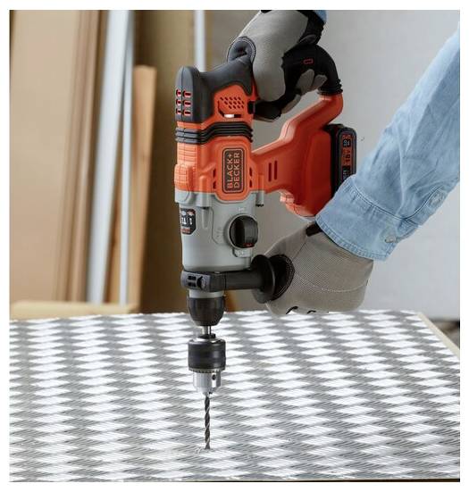 Eine Person mit Handschuhen verwendet einen kabellosen Elektroschrauber, um an einer karierten Metalloberfläche zu arbeiten.