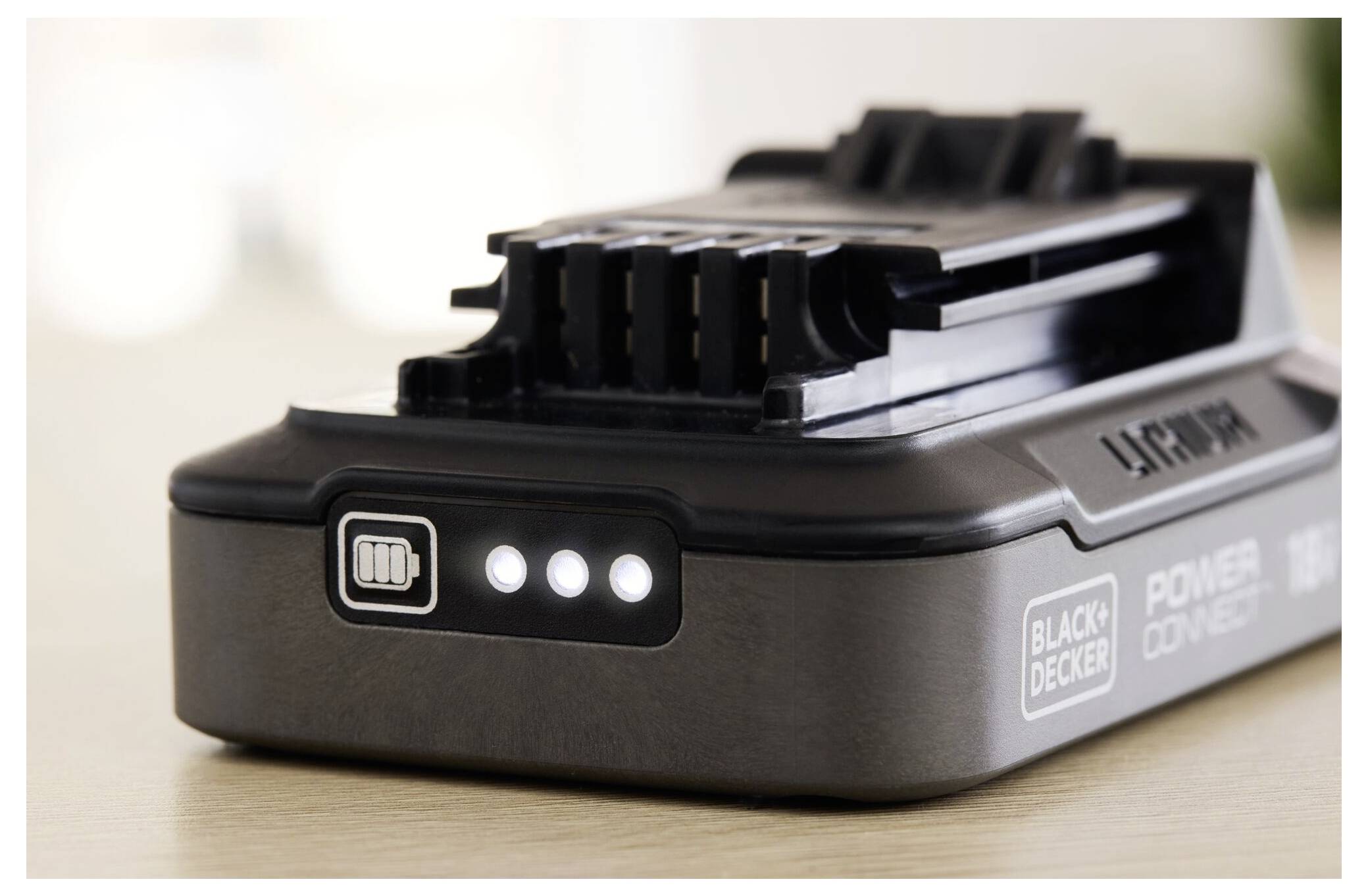 Eine Nahaufnahme einer aufladbaren Batterie mit drei leuchtenden Anzeigelichtern, die zeigen, dass sie geladen ist. Der Markenname ist auf der Seite sichtbar.