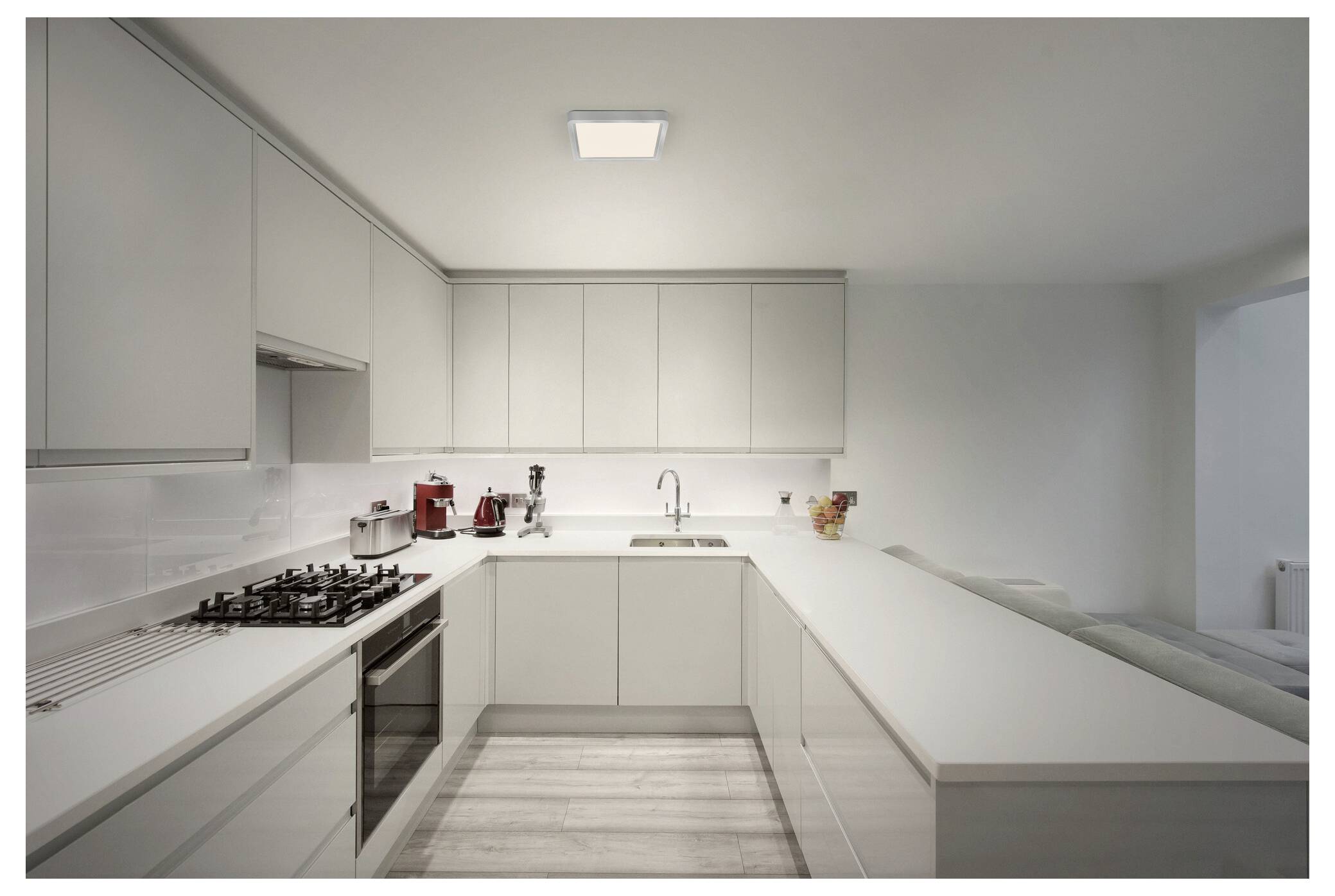 Ein rundes, modernes Deckenleuchte mit einer glatten weißen Oberfläche und einem dunklen Rahmen, montiert an einer hellgetönten Decke.