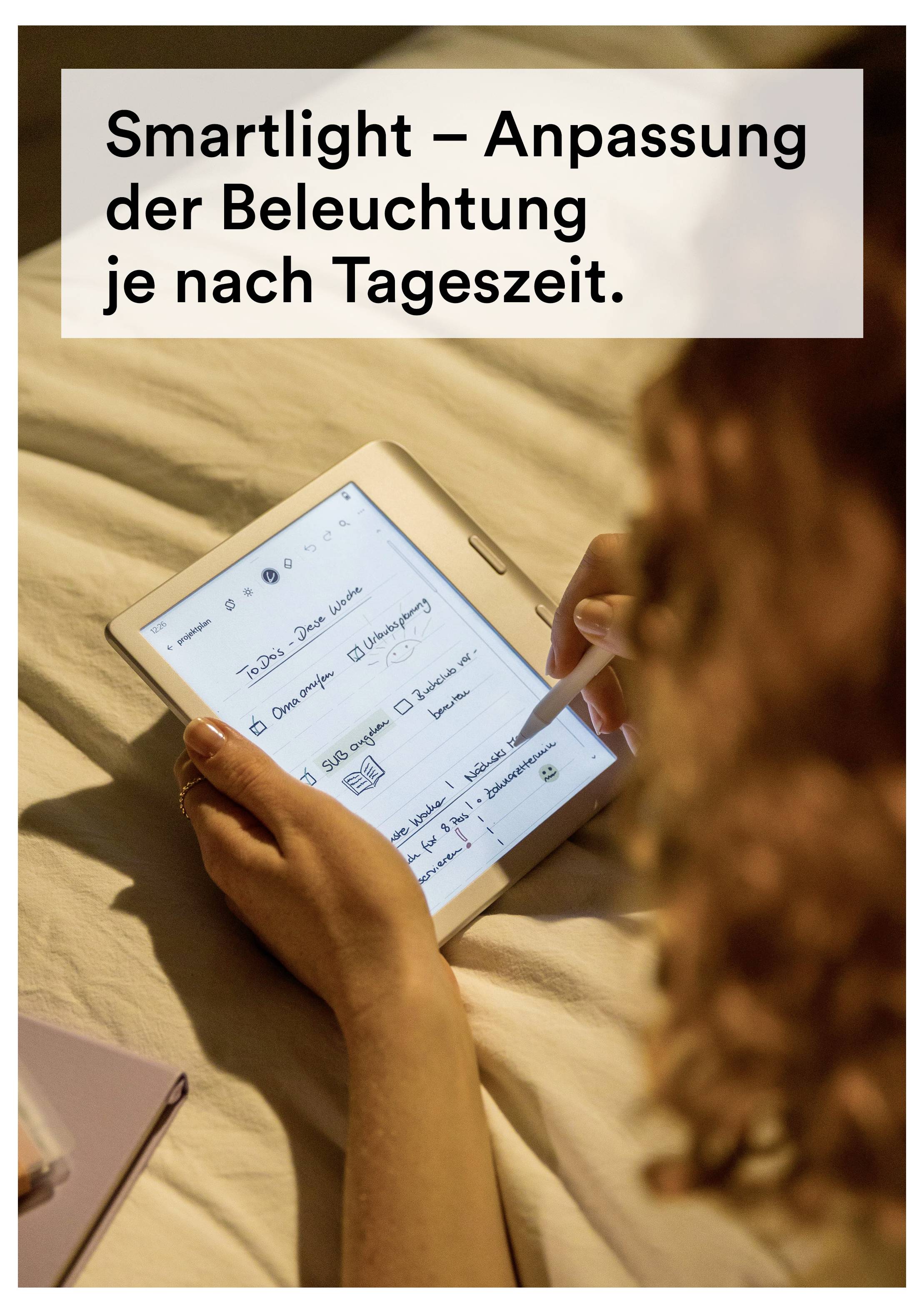 Ein Tablet mit E-Books auf dem Display ruht auf einem Tisch neben einer Tasse Kaffee vor grünem Hintergrund. Der Text lautet „Farbdisplay sorgt für lebendige Inhalte.