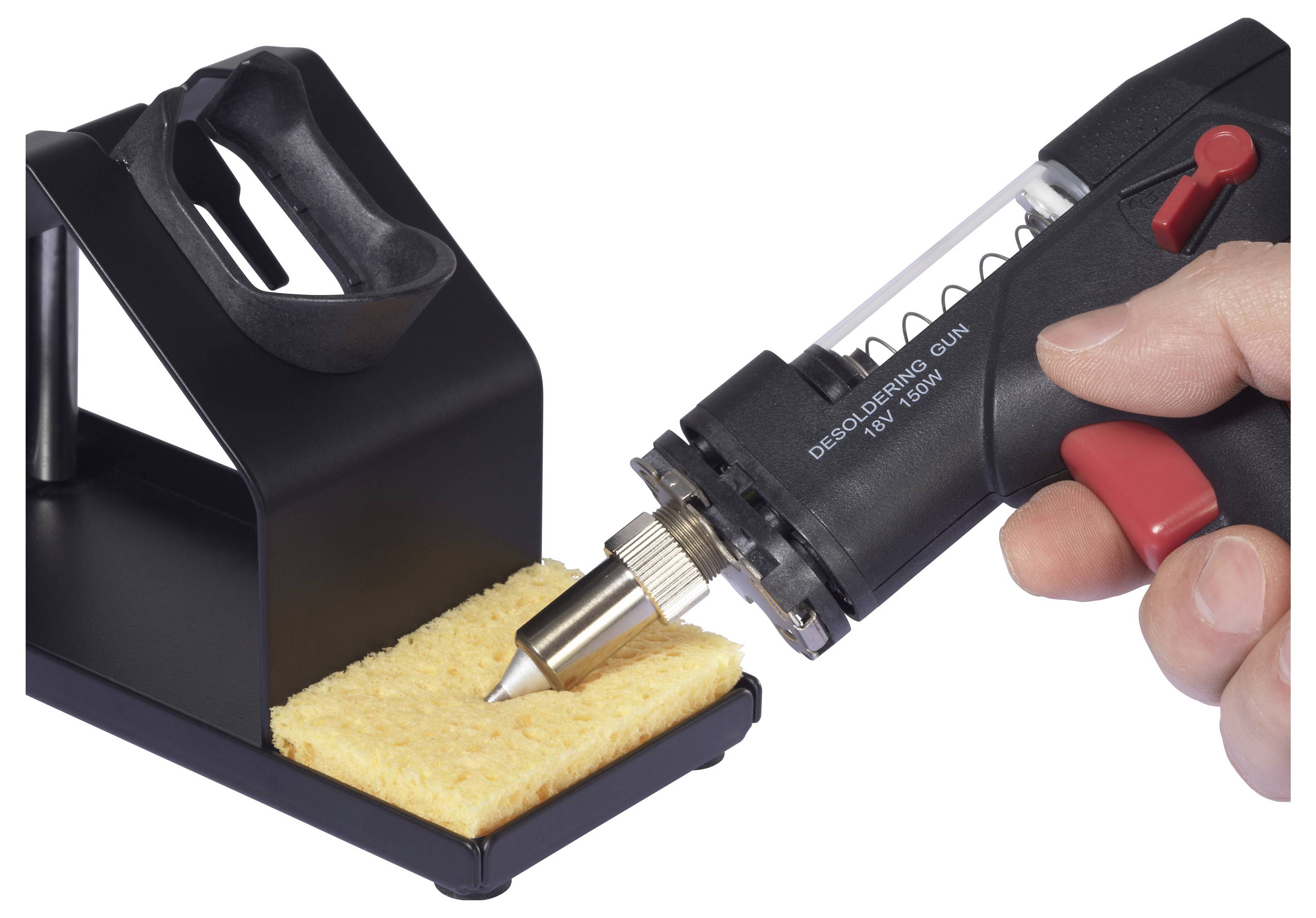 Eine Hand hält eine Entlötpistole mit ihrer Spitze auf einem gelben Schwamm auf einem schwarzen Ständer, bereit zum Reinigen.