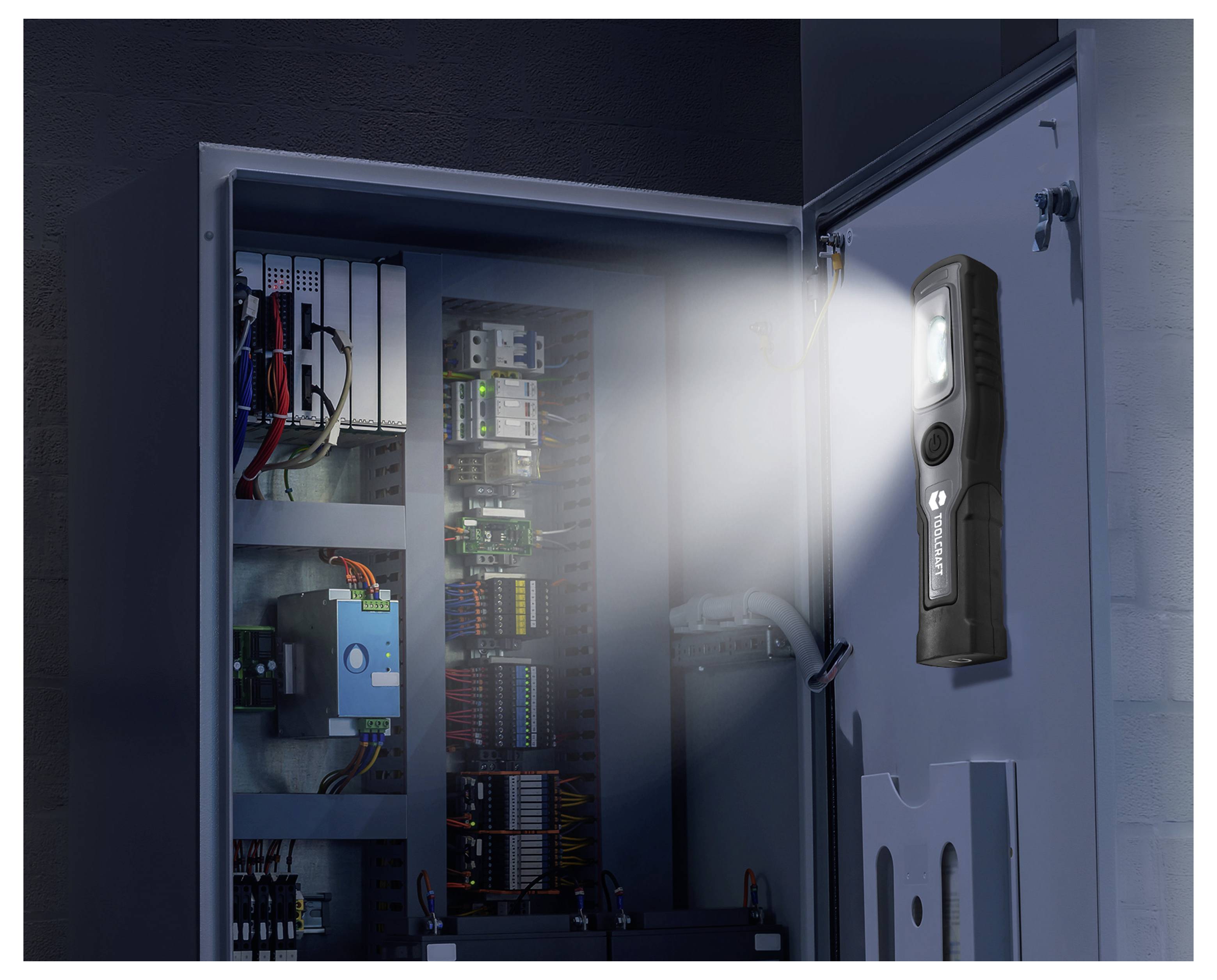 Inspektionsleuchte, die auf einem offenen elektrischen Schaltschrank montiert ist und die interne Verdrahtung und Schaltkomponenten beleuchtet.