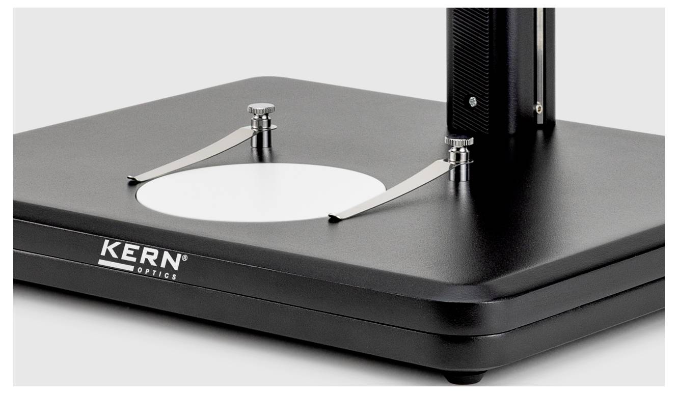 Eine schwarze Basis mit Metallarmen und einer kreisförmigen weißen Plattform, Teil eines KERN Optics-Geräts, das für optische Experimente oder Messungen verwendet wird.